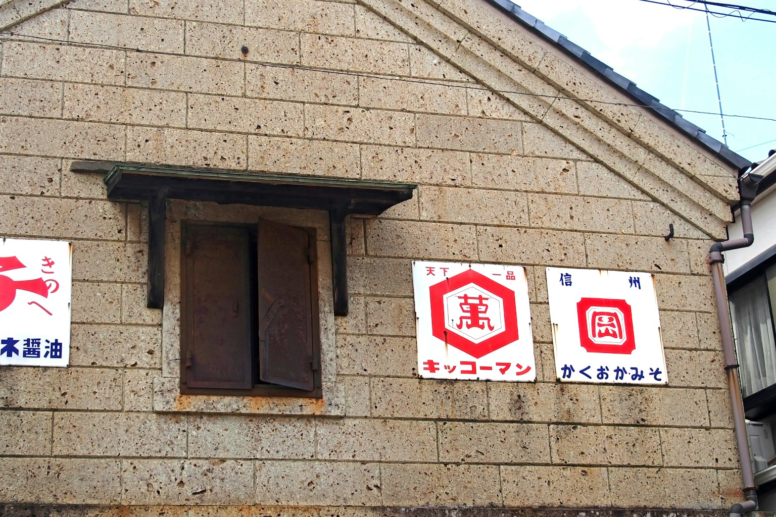 Mặt ngoài của một tòa nhà cũ với biển hiệu và cửa sổ gỗ