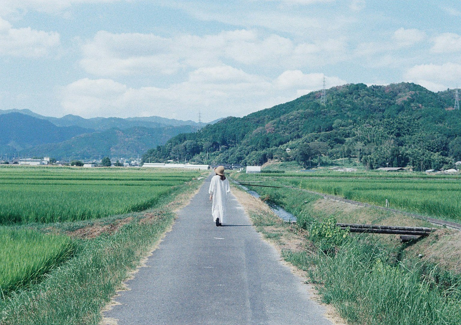 在藍天下的一條鄉村道路上行走的人