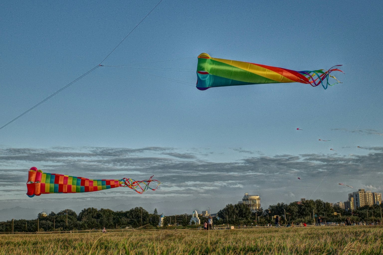 青空の下で飛ぶカラフルな凧と人々