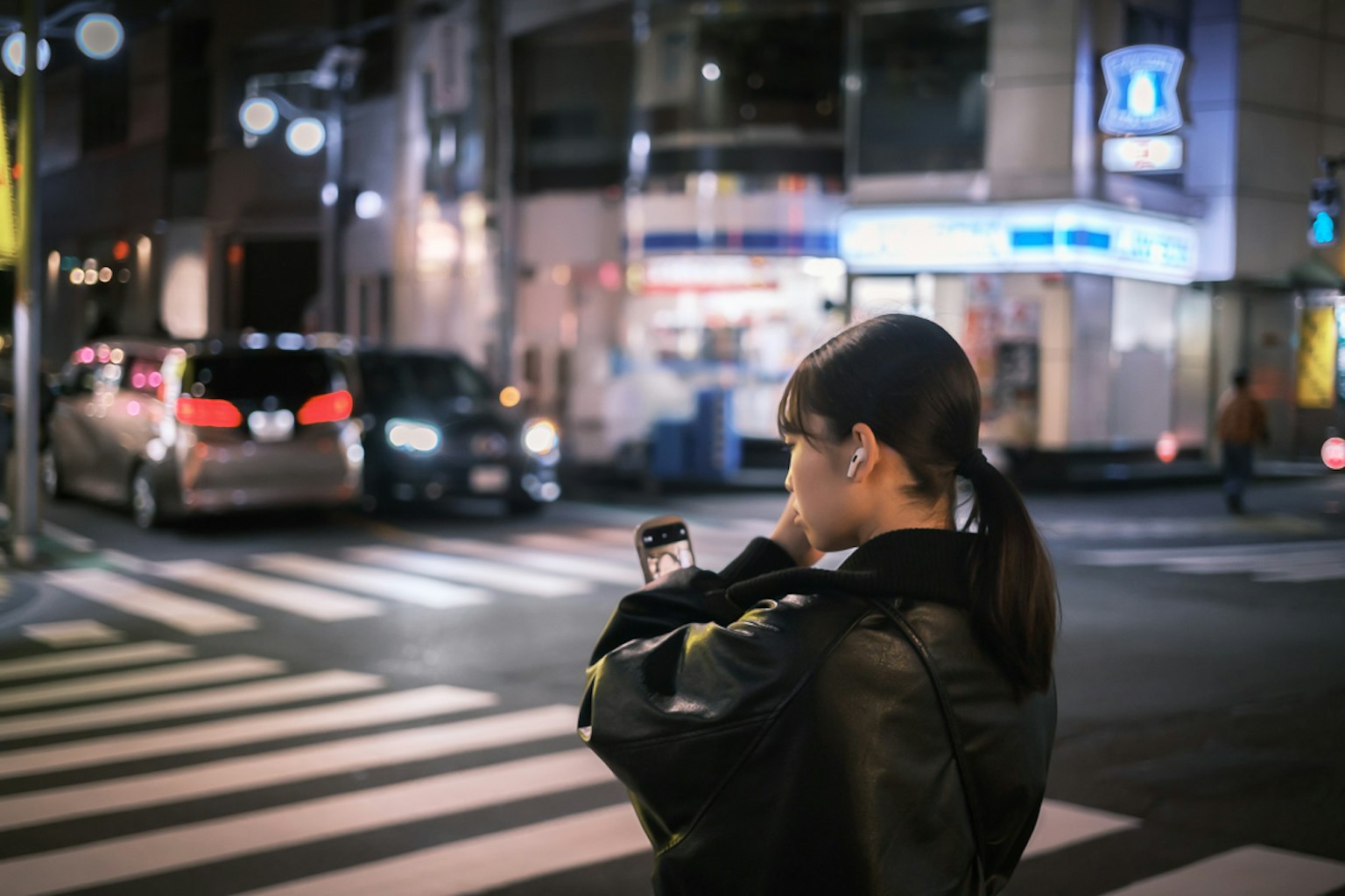 夜晚城市交叉口使用智能手机的女性