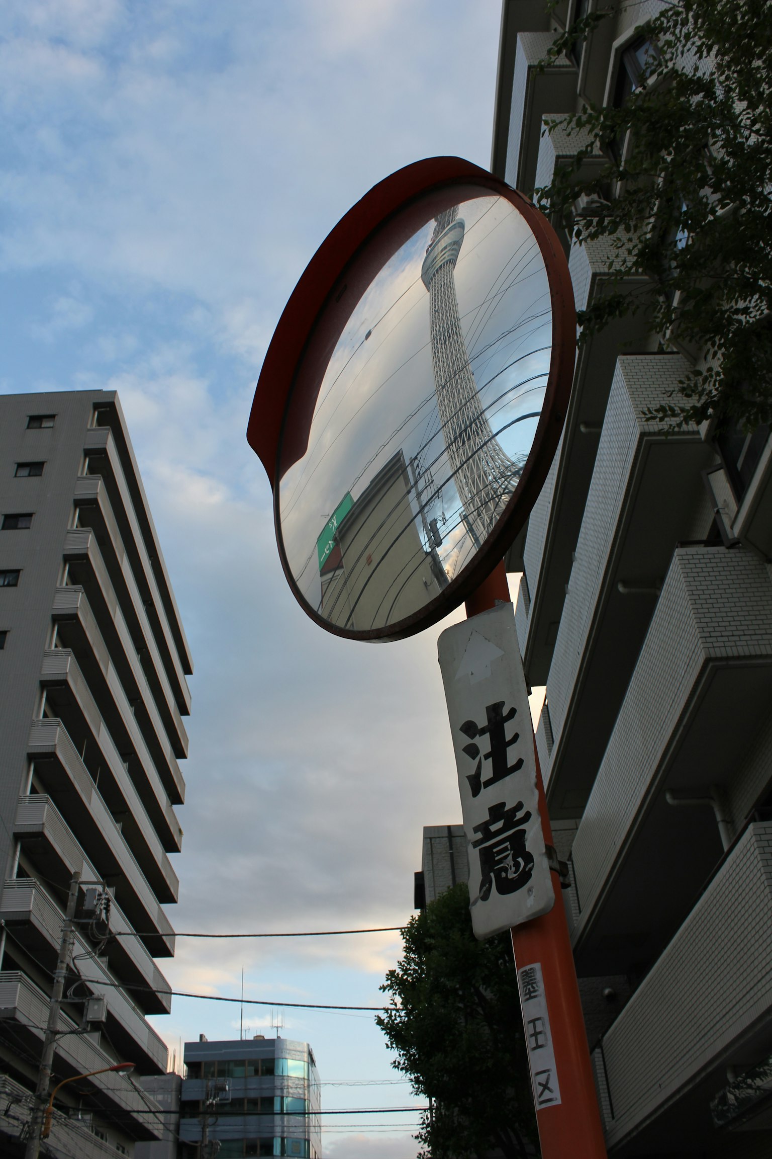Bild zeigt einen Straßenpiegel, der einen bewölkten Himmel reflektiert