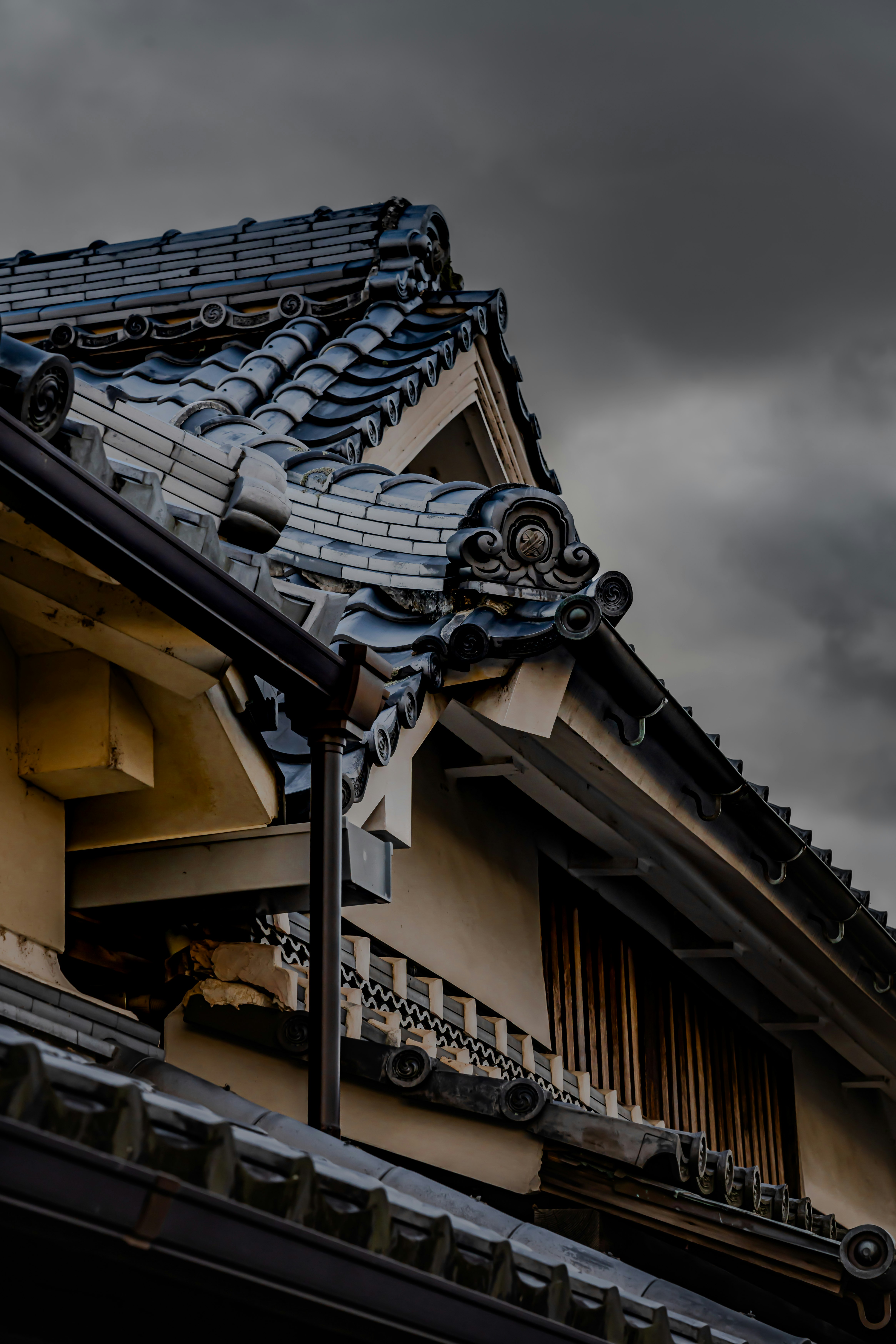 黒い空を背景にした伝統的な瓦屋根の町家の外観