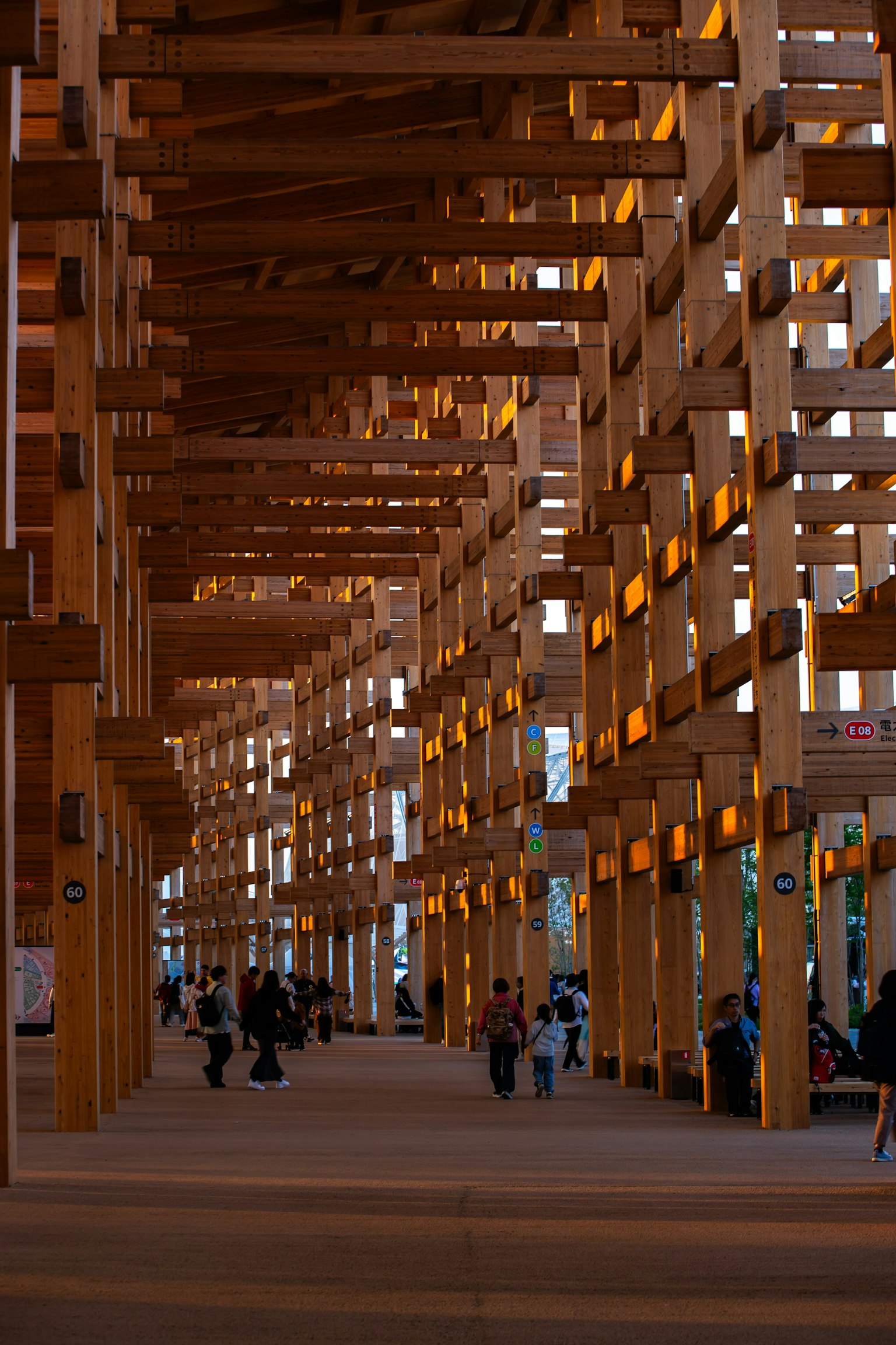 Siluetas de personas debajo de una estructura de madera arquitectura única con luz diurna filtrando