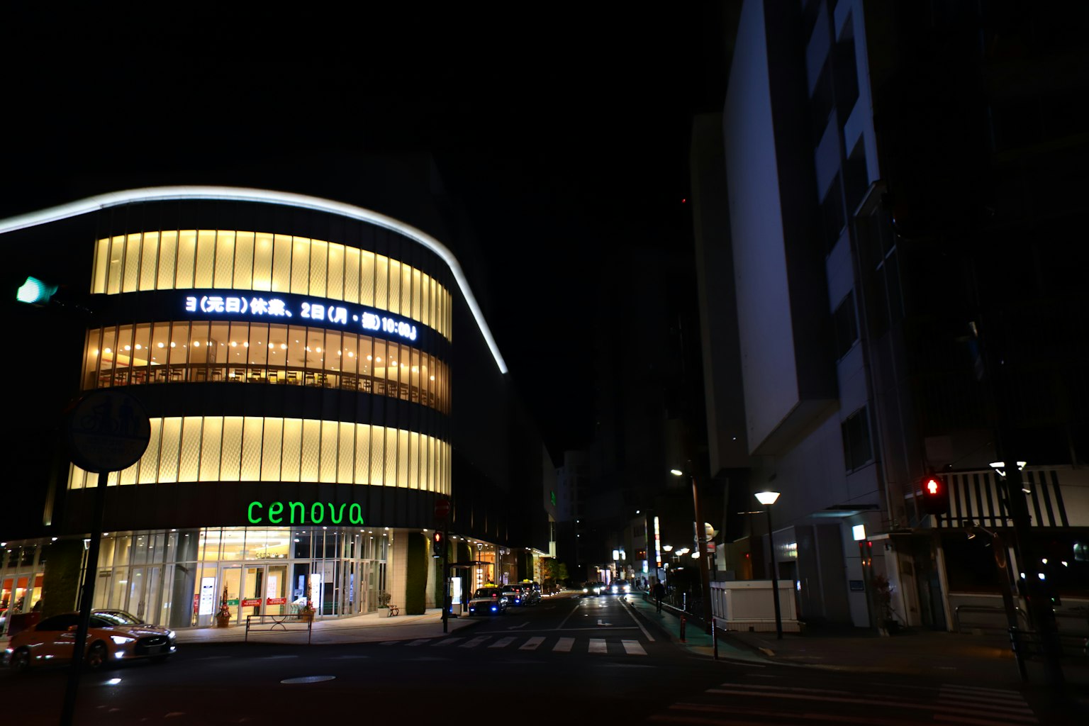 Vista notturna di una strada vivace con un edificio commerciale illuminato