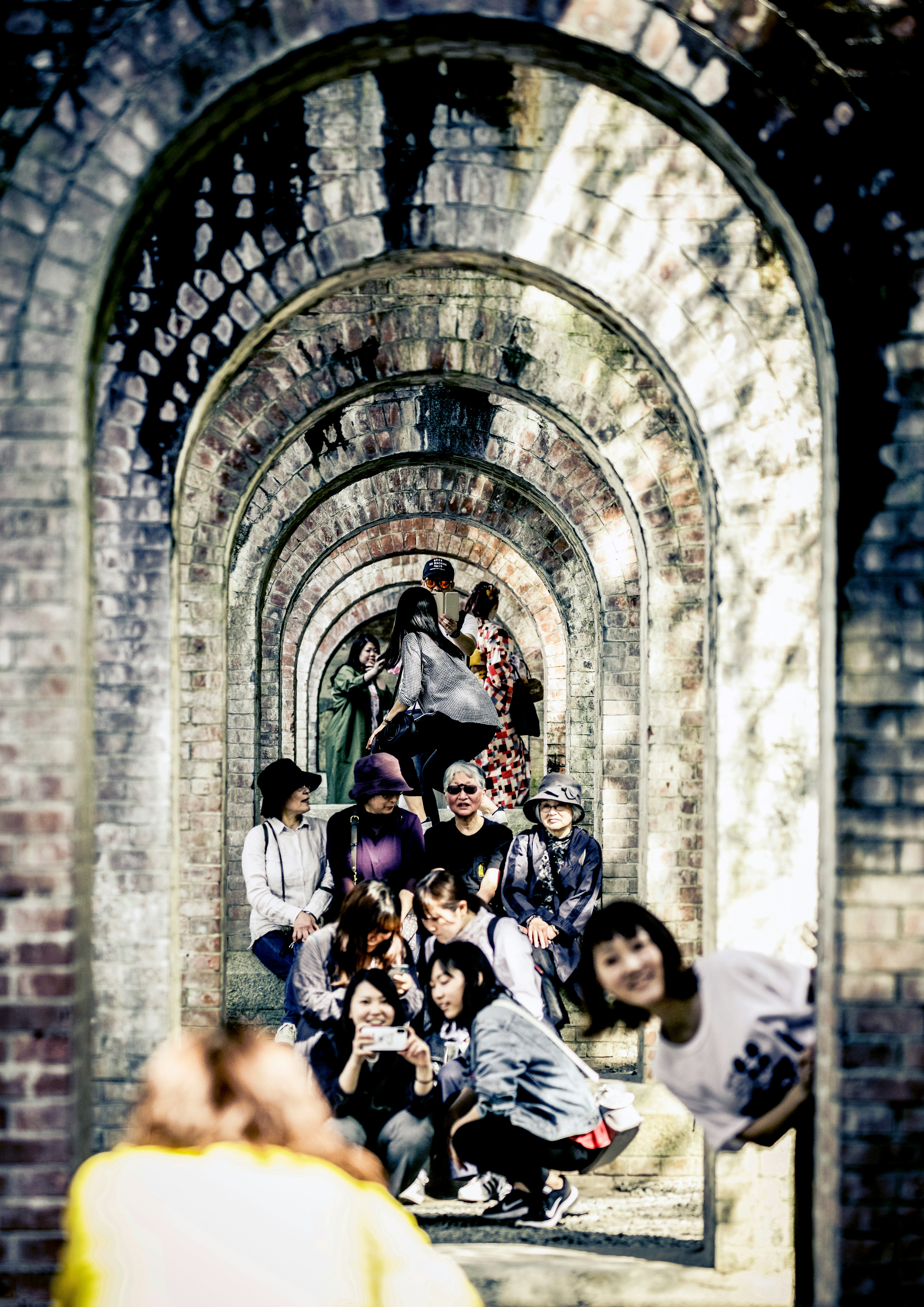 Des touristes posant pour des photos dans les arches en pierre du Nanzen-ji Suirōkaku
