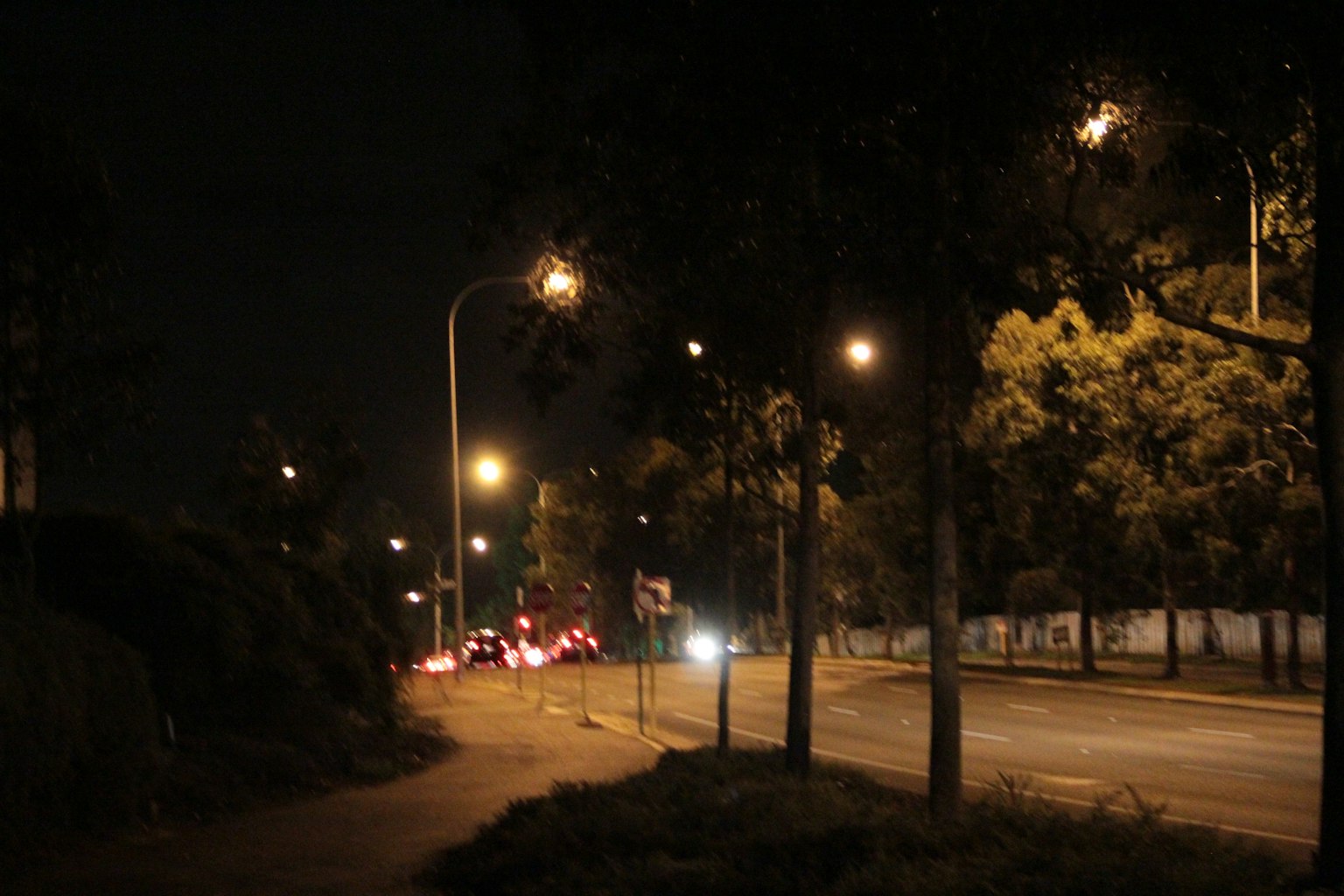 夜晚街道場景 明亮的路燈和可見的汽車燈光