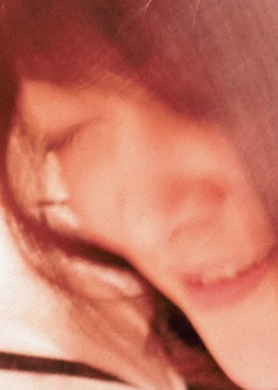 赤みのある光の中で寄り添う横顔の女性