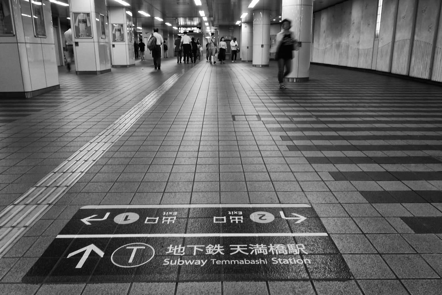 Floor sign indicating Subway Tenman Station with directional arrows