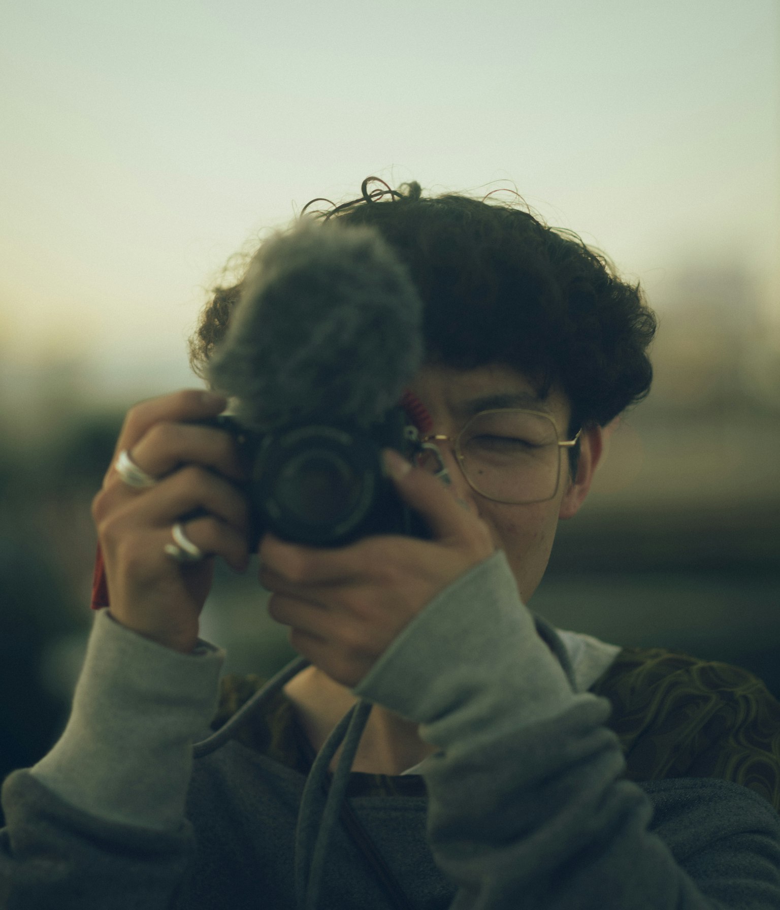 一位年輕男性手持相機的肖像背景模糊