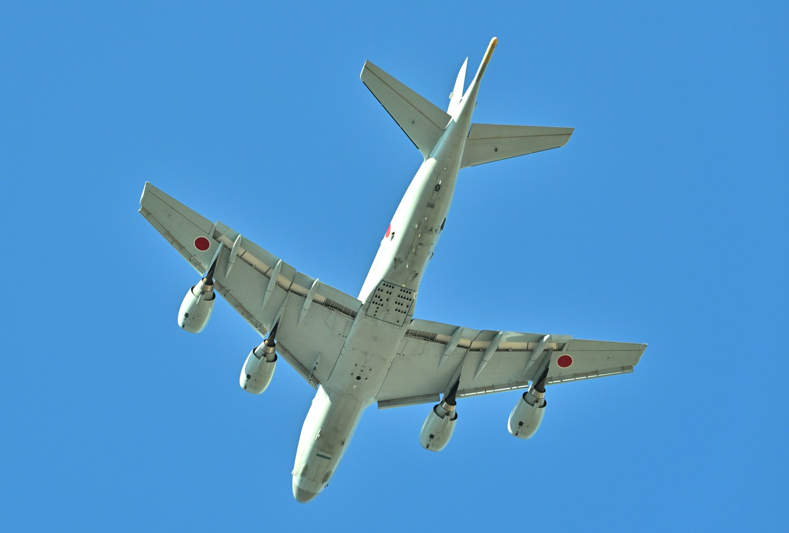 Vista inferiore di un aereo che vola contro un cielo blu
