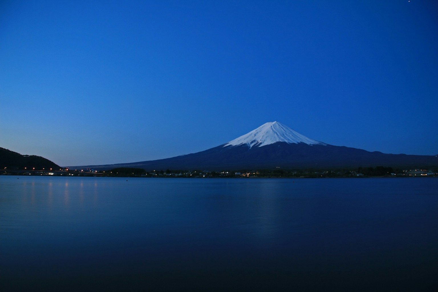 Pemandangan indah Gunung Fuji yang memantul di danau di bawah langit malam biru