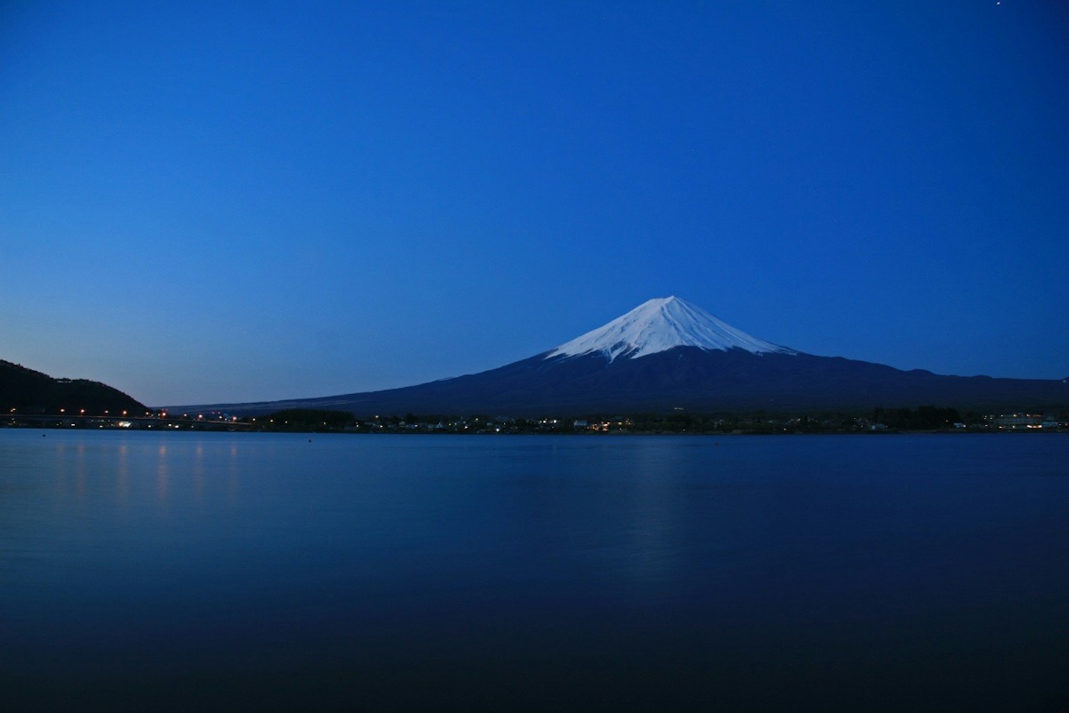Beautiful landscape of Mount Fuji reflecting on the lake under a blue night sky
