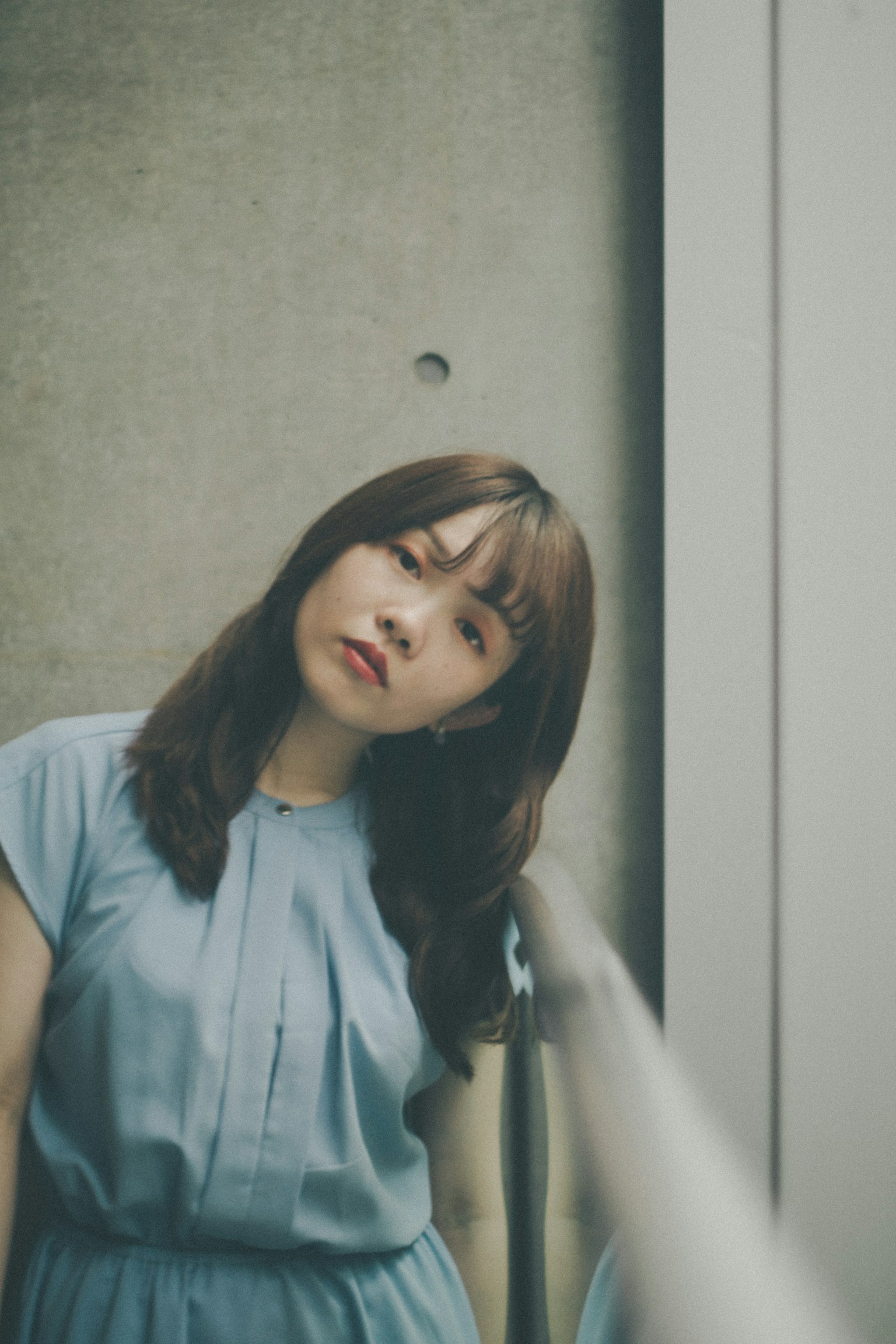 穿着蓝色裙子的女性倾斜着头
