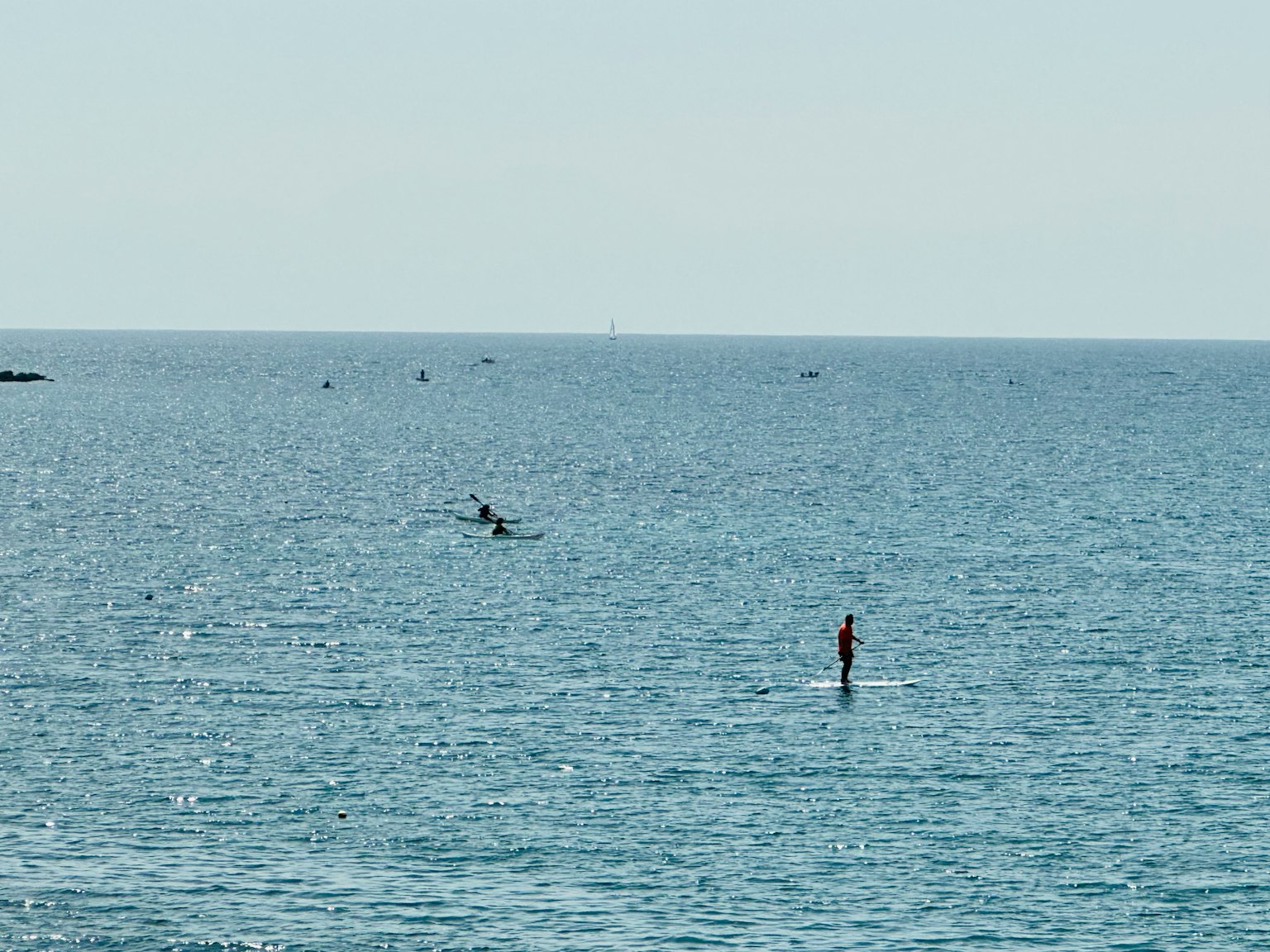 A person enjoying stand-up paddleboarding on a calm sea