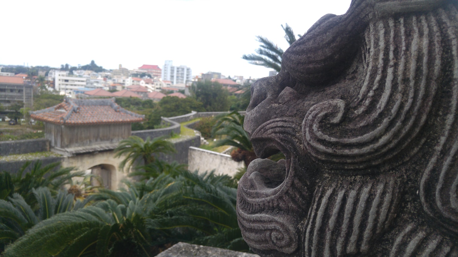Escultura tradicional de Shisa en Okinawa con paisaje circundante