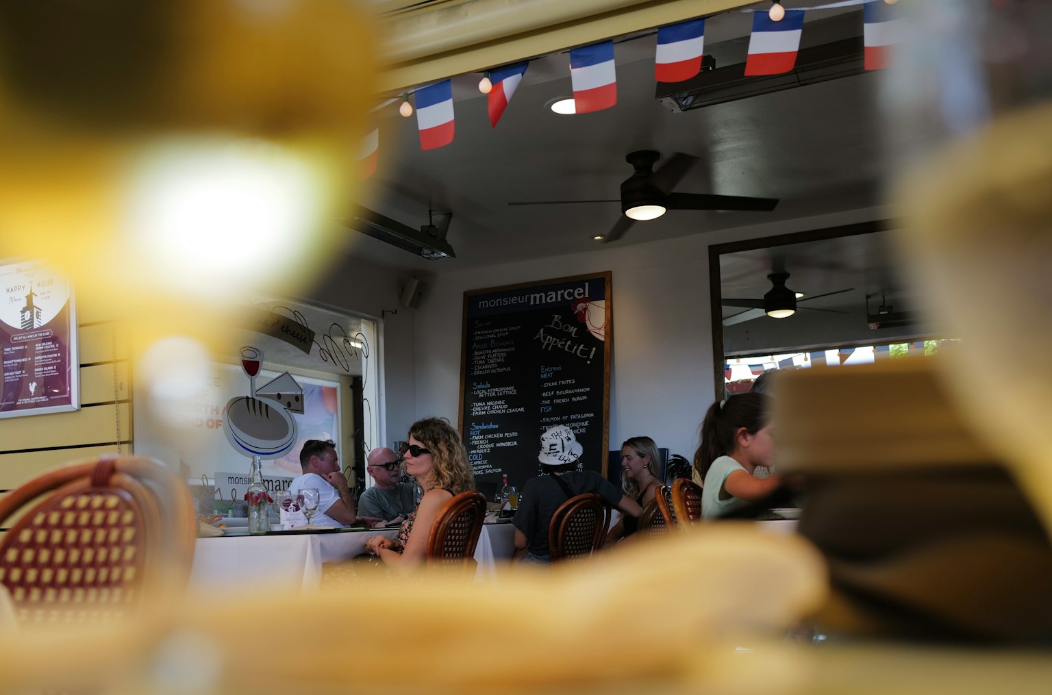 Vue à travers un verre montrant des gens dînant à l'intérieur d'un restaurant avec des drapeaux décoratifs