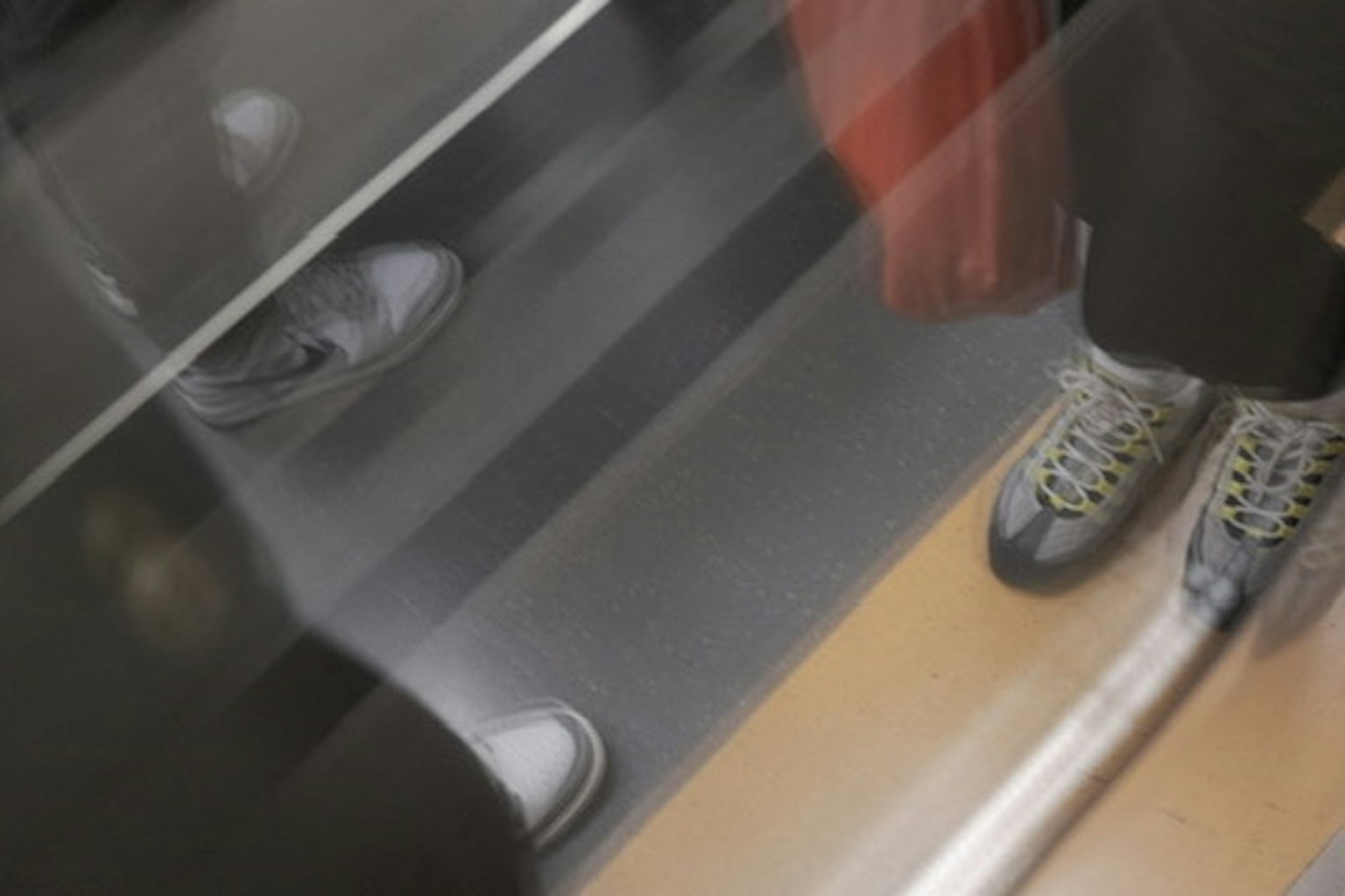 Refleksi sepatu dan kaki di dalam lift