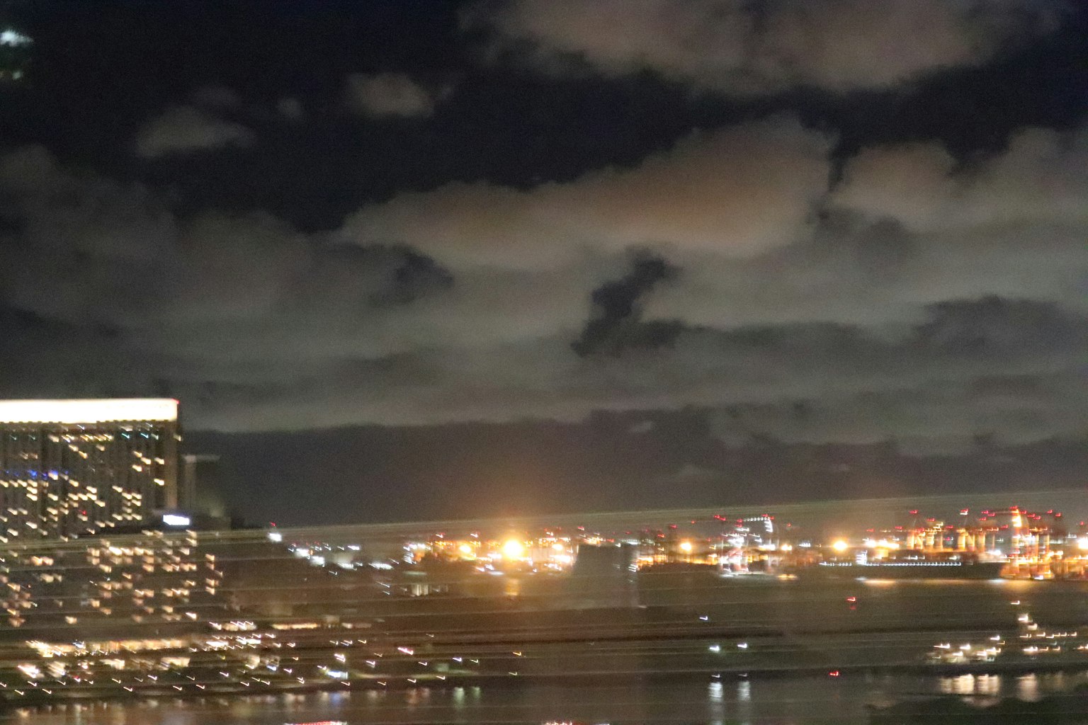 Pemandangan kota malam dengan awan dan lampu
