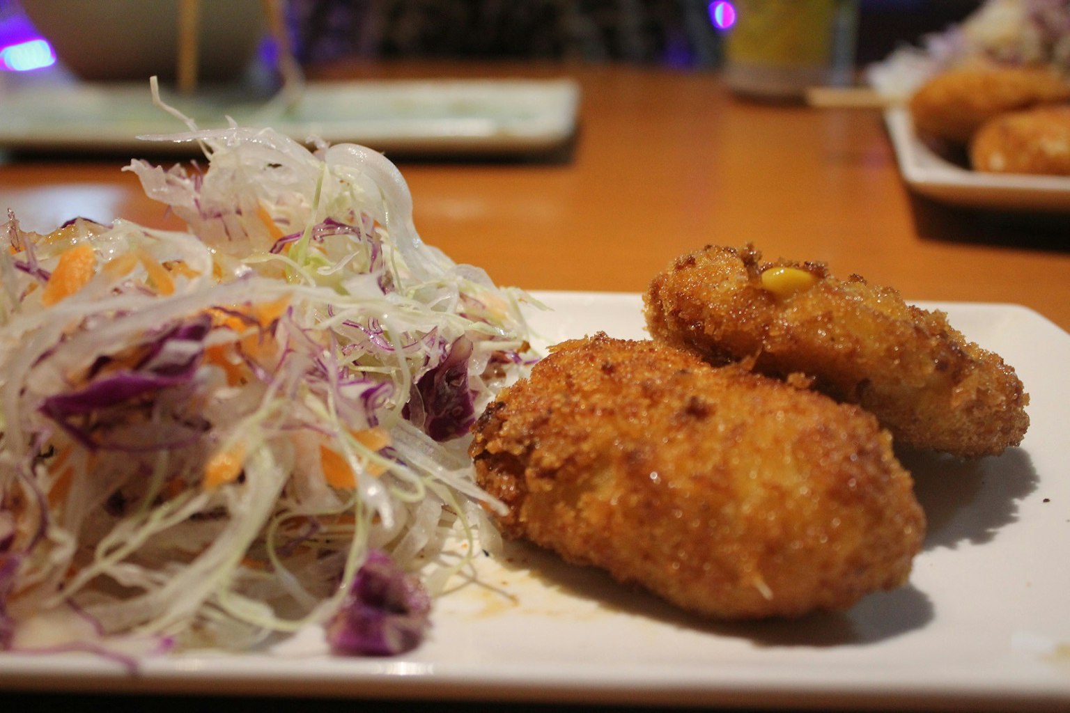 Bild von Kroketten und Salat auf einem Teller serviert