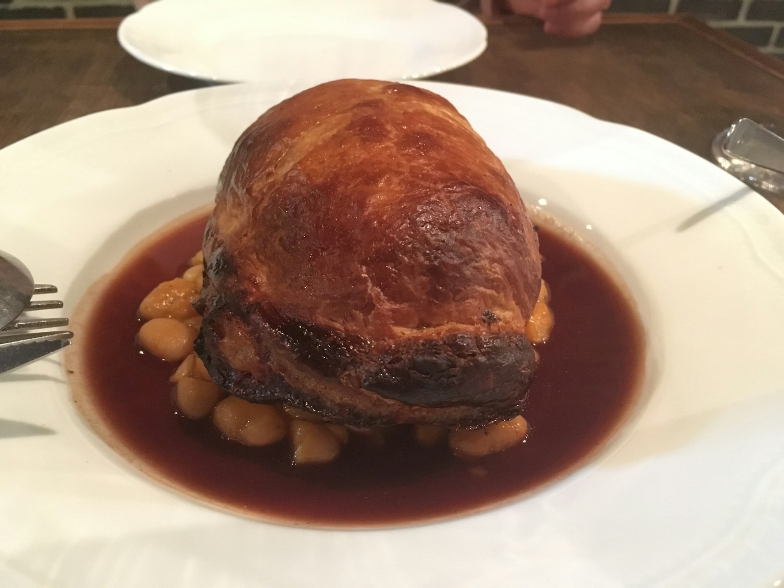 A beautifully presented meat dish on a plate with sauce surrounding it