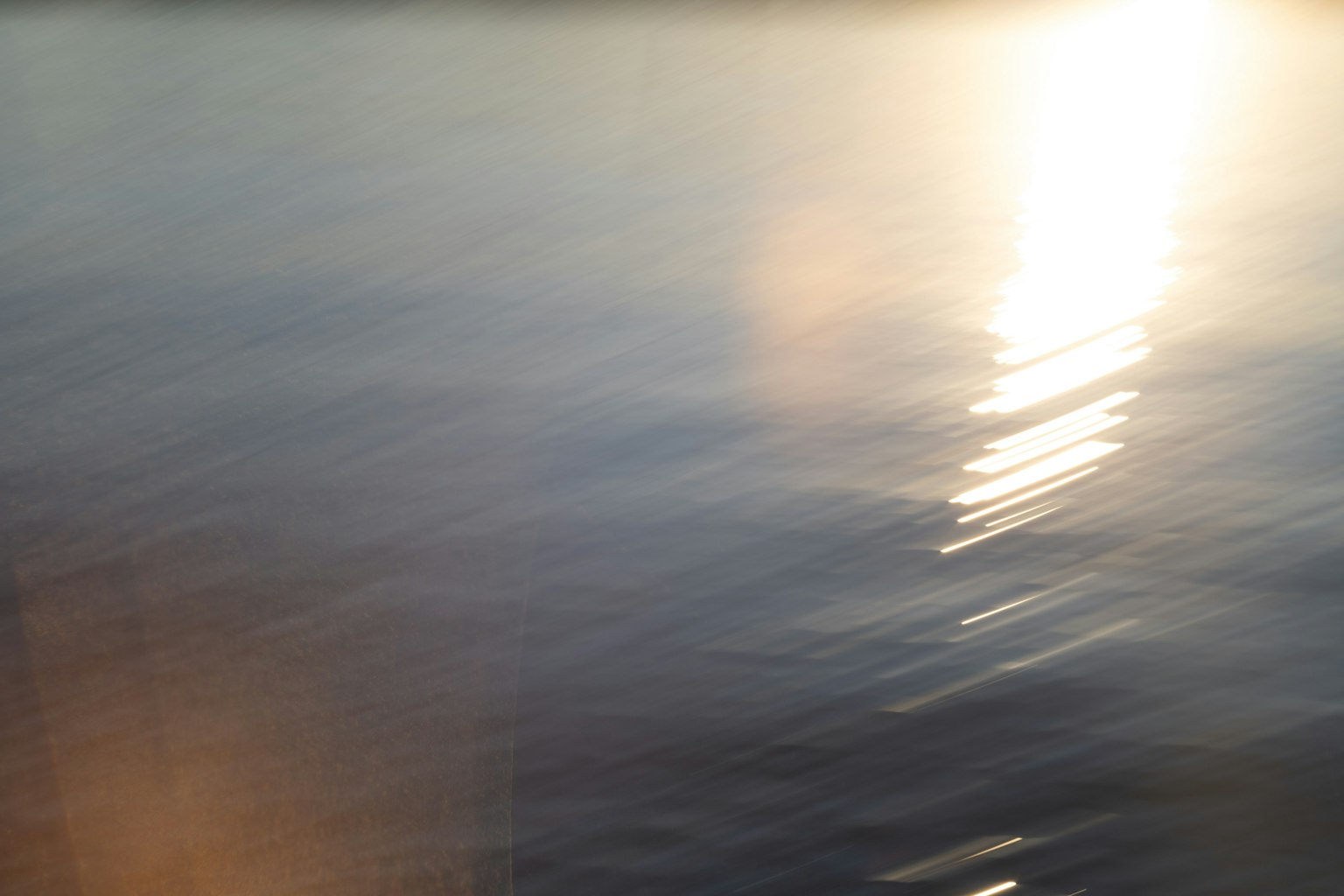 Imagen borrosa de la luz reflejándose en la superficie del agua