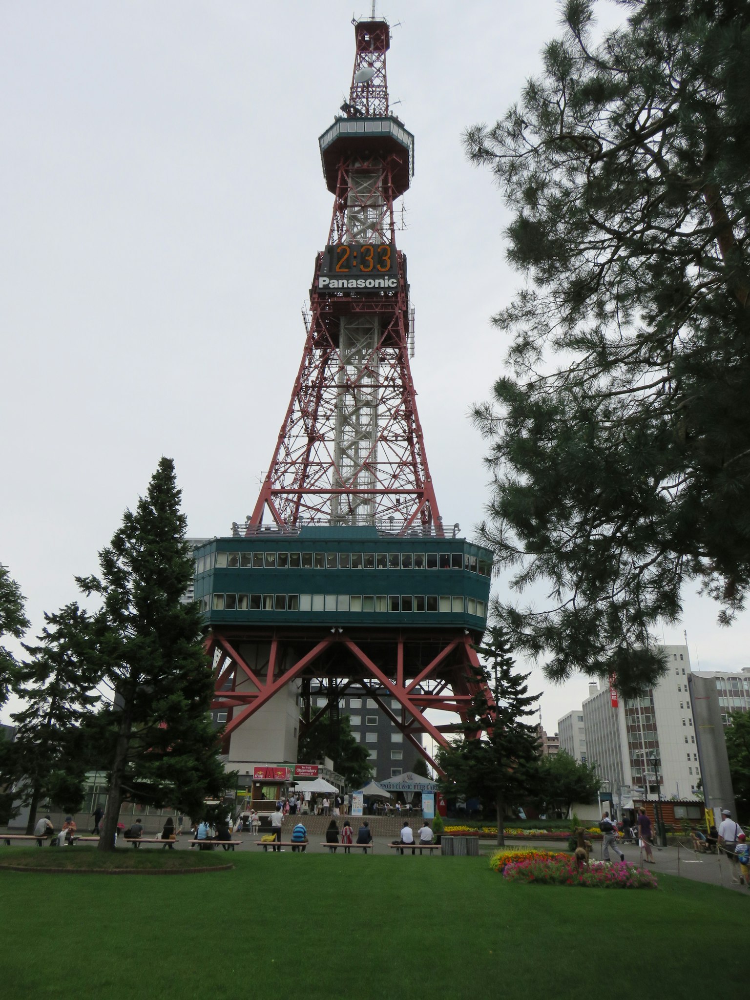 大通公園內的札幌電視塔照片，周圍有綠色樹木和遊客