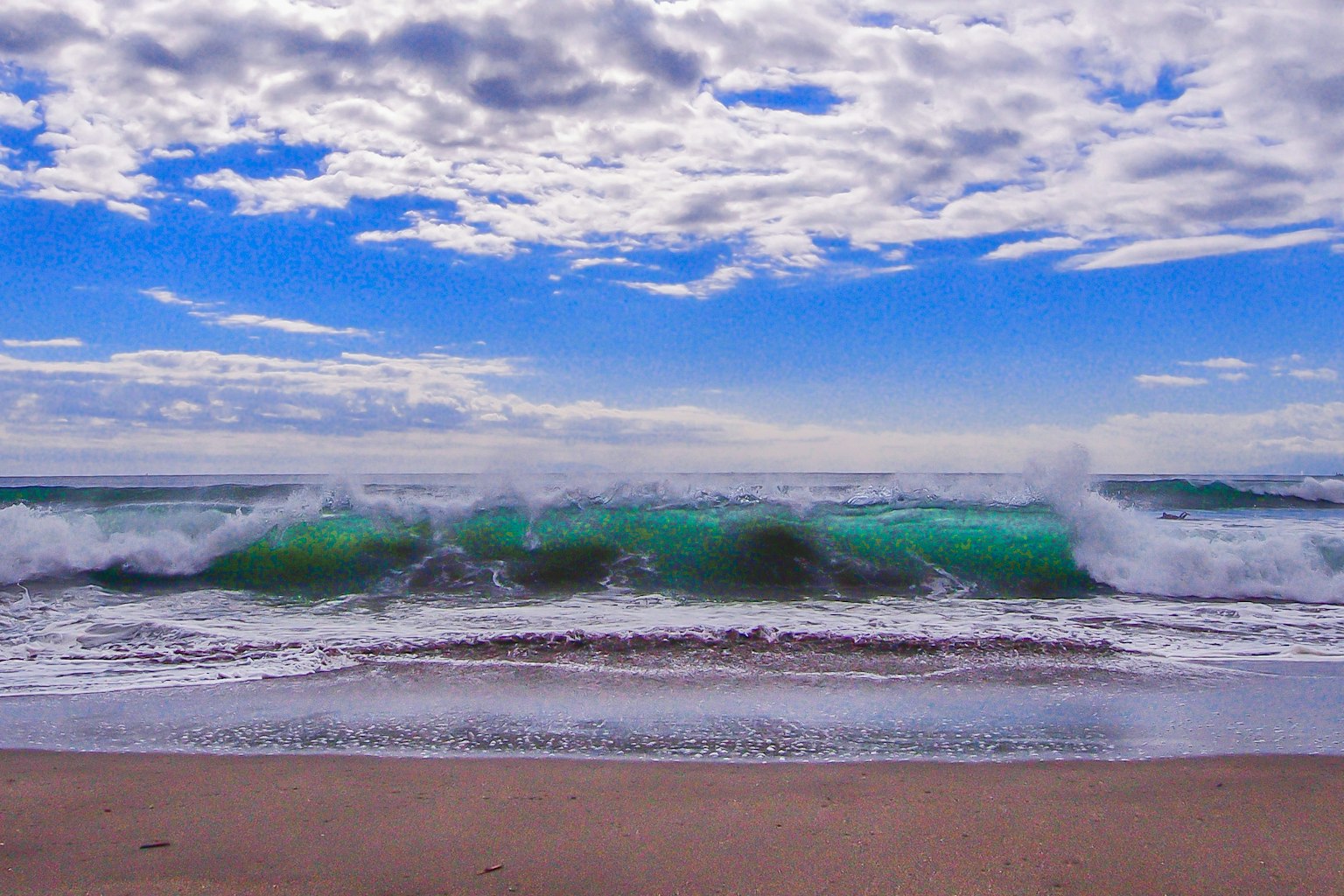 Scène côtière avec des vagues s'écrasant et un ciel bleu