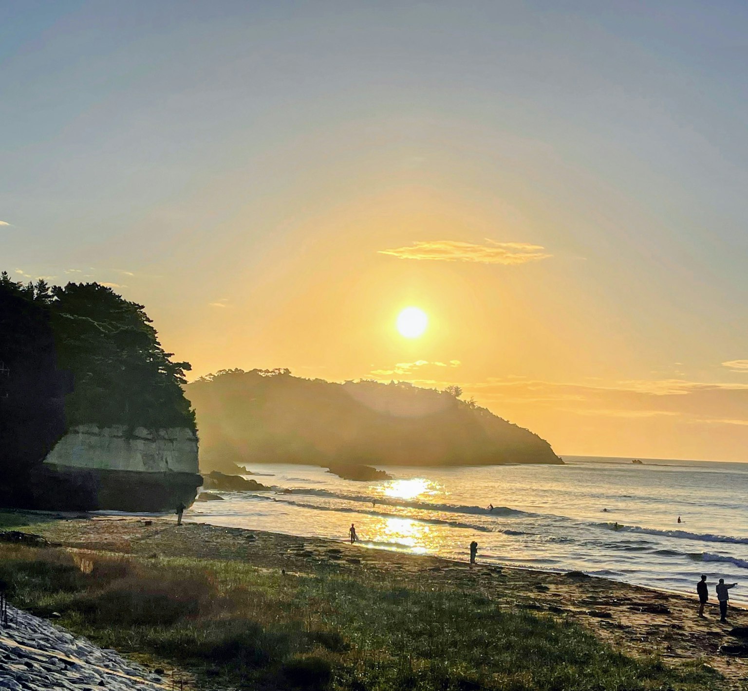 Hermoso paisaje de playa con la puesta de sol sobre el océano personas caminando