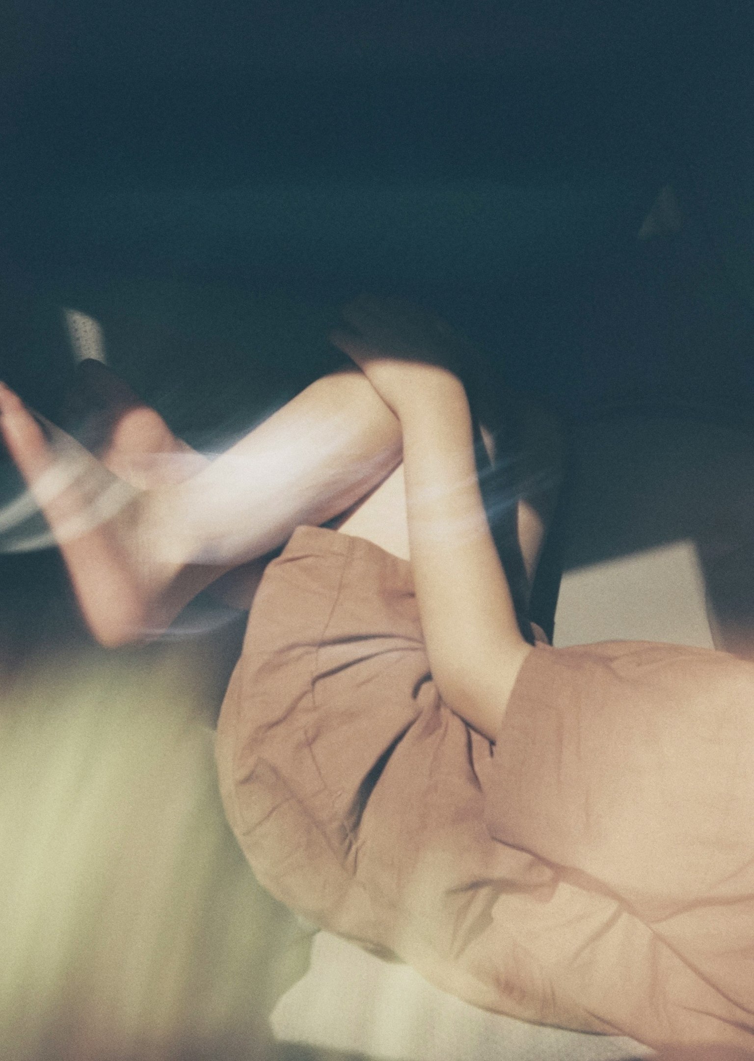 柔らかい光の中で横たわる人の足と腕の部分