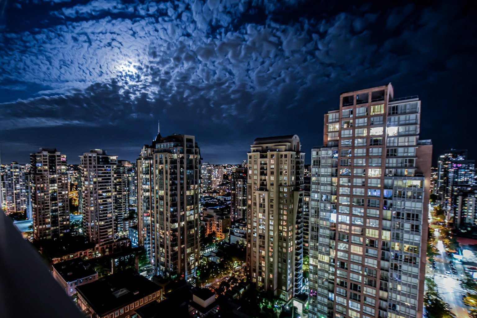 夜间城市天际线与明亮的月亮和纹理云