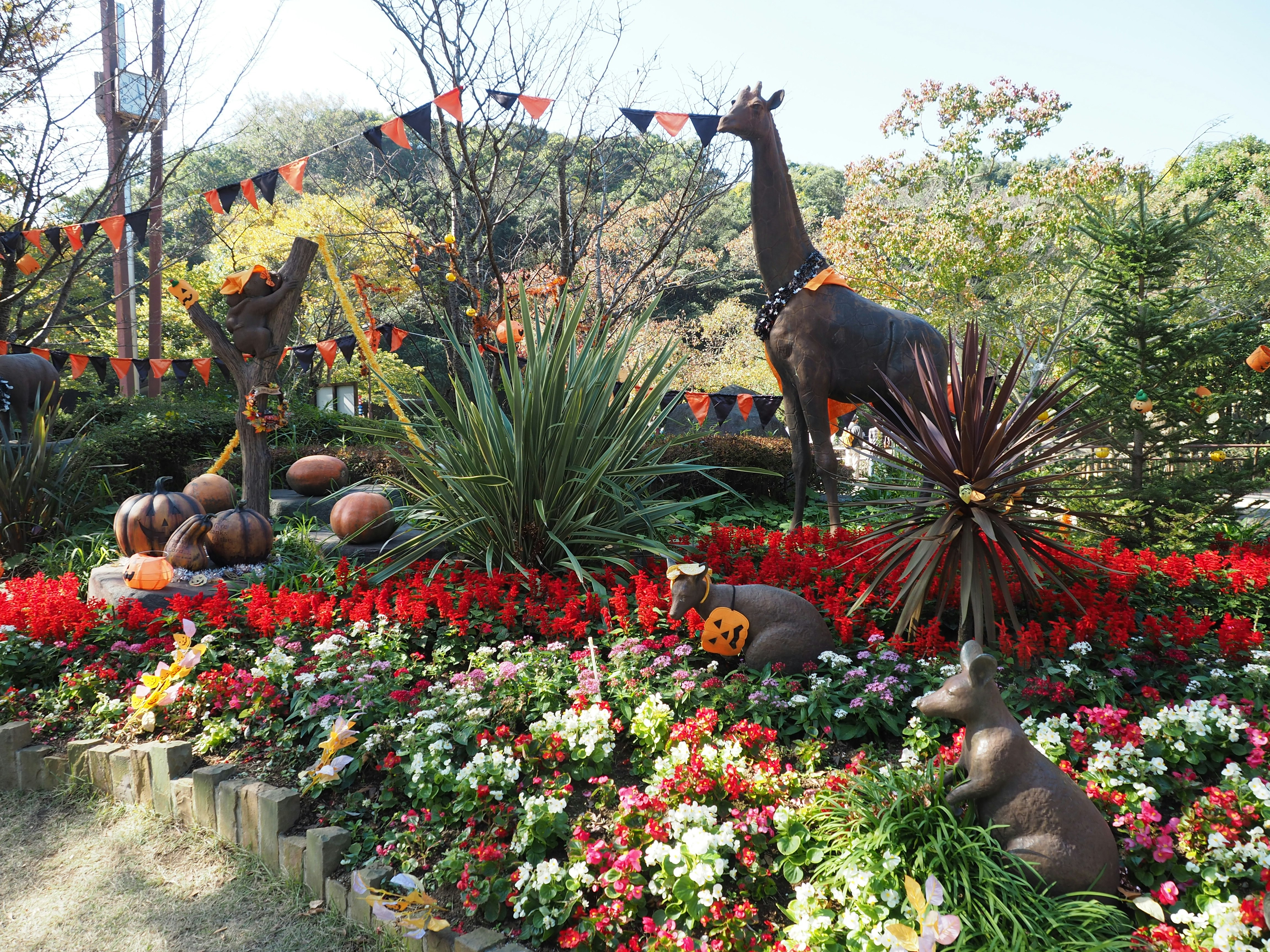 garden with animal statues posing in front of colorful flower beds