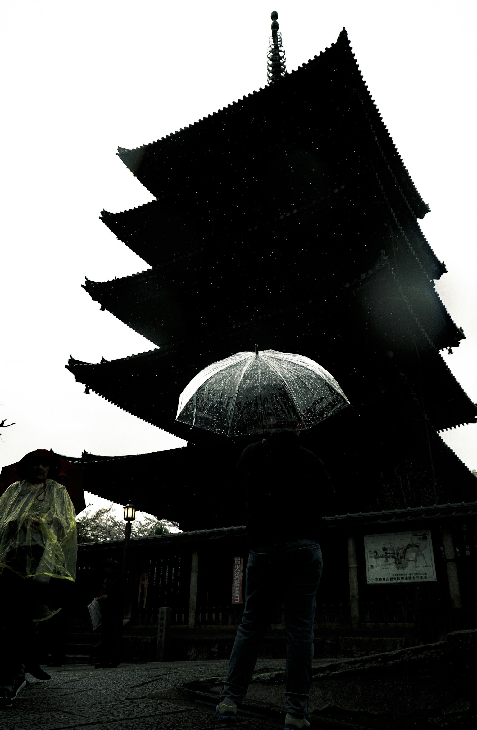 Five-story pagoda in the snow with a person holding an umbrella