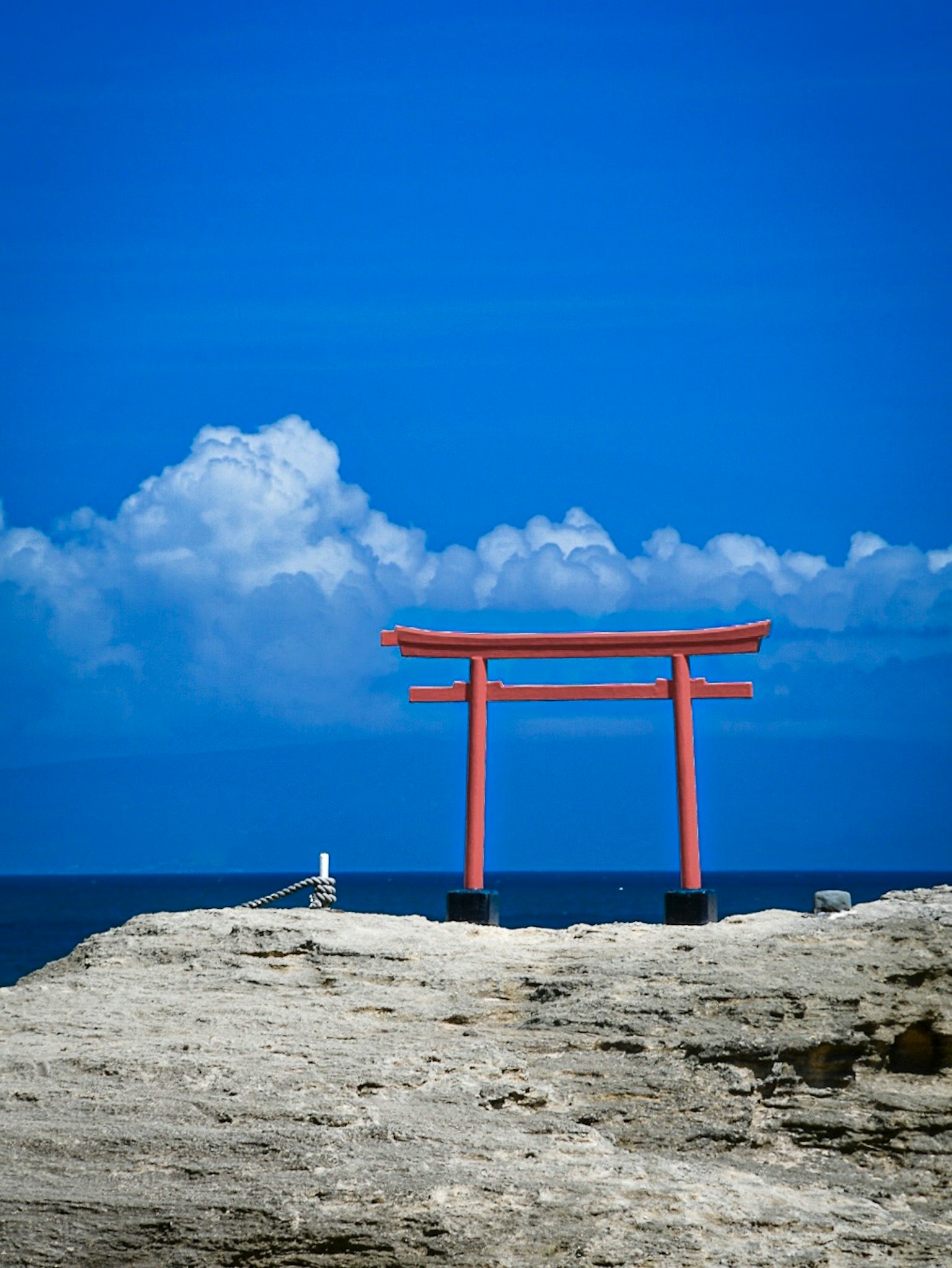 Portale torii rosso con sfondo di cielo e mare blu