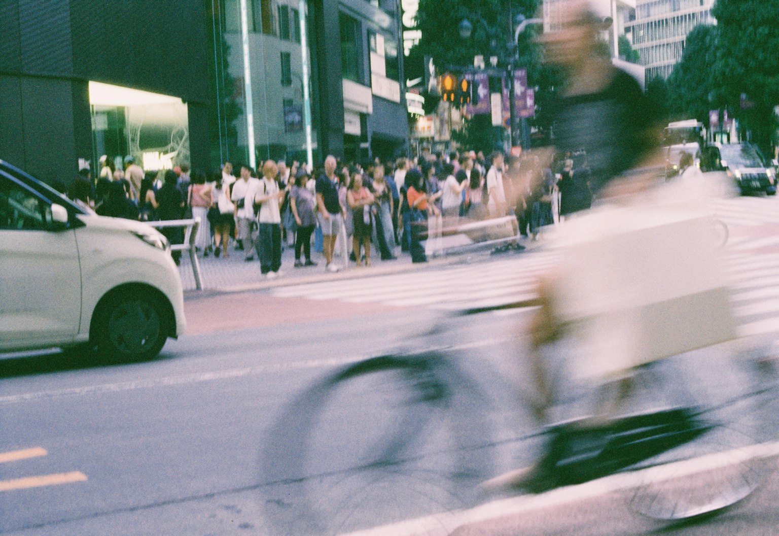 自転車に乗った人物がぼやけている街の風景 多くの人々が行き交う通り