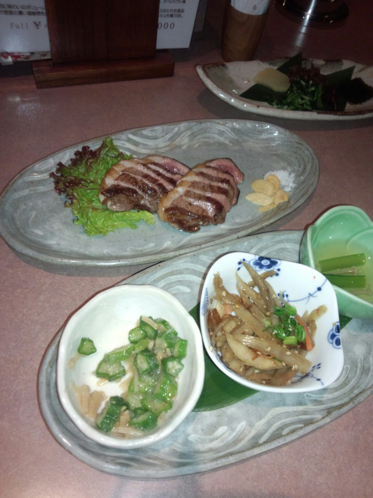 Beautifully arranged Japanese cuisine featuring grilled meat and small side dishes