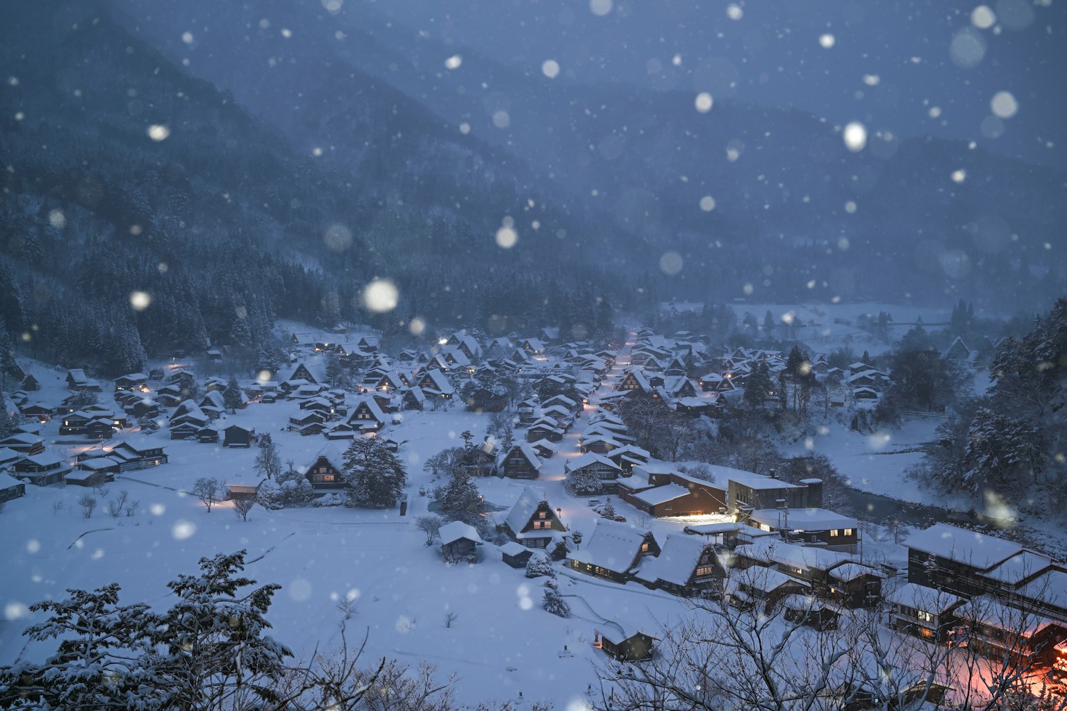 Paysage d'hiver d'un village enneigé avec des maisons traditionnelles entourées de montagnes