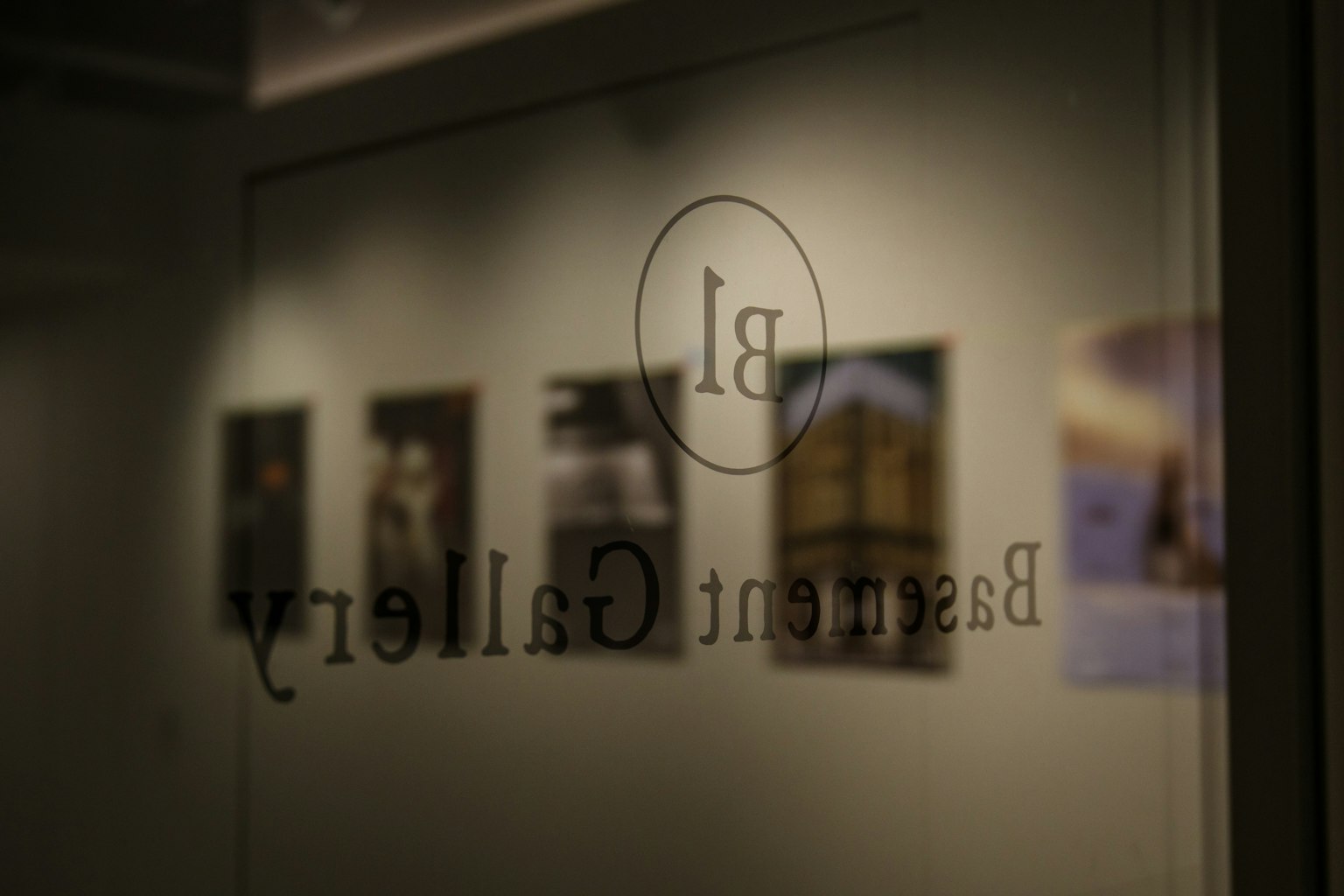 Reflection of the Besant Gallery sign with displayed photographs in the background