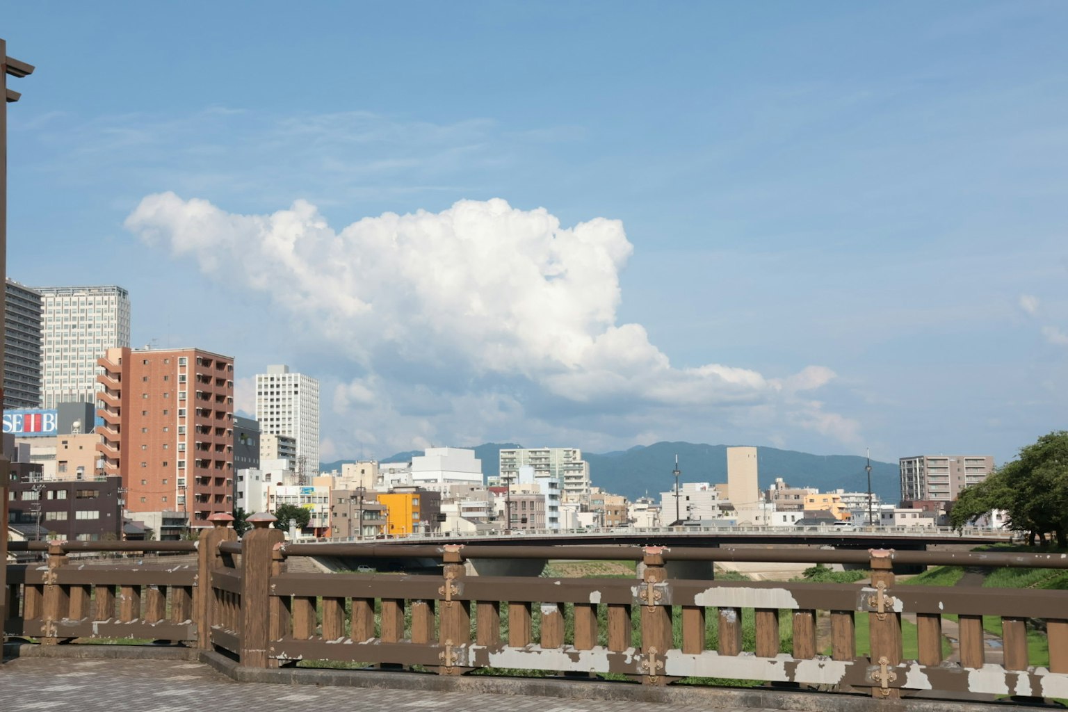 Pemandangan kota dengan langit biru dan awan pegangan kayu jembatan terlihat