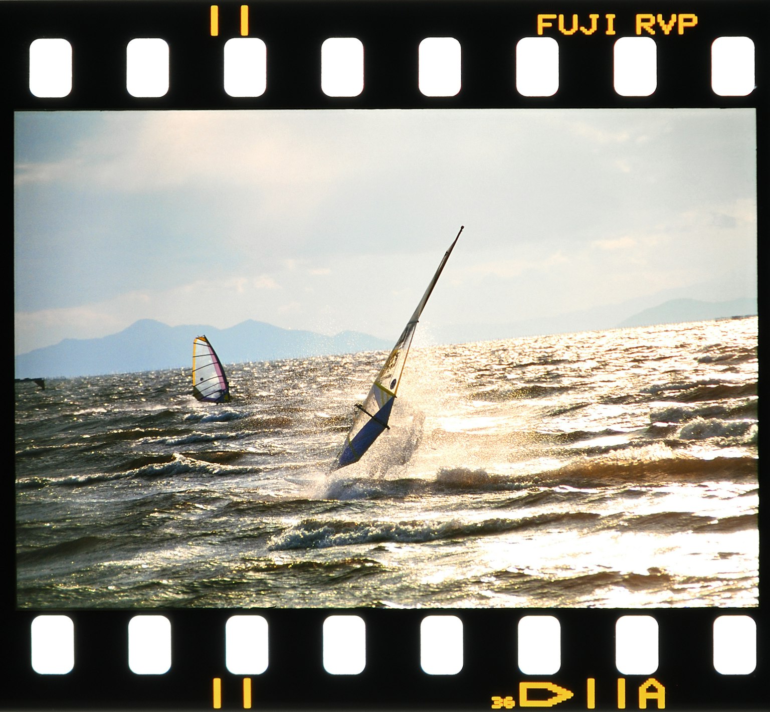 Surfistas a vela deslizándose sobre las olas bajo un cielo nublado