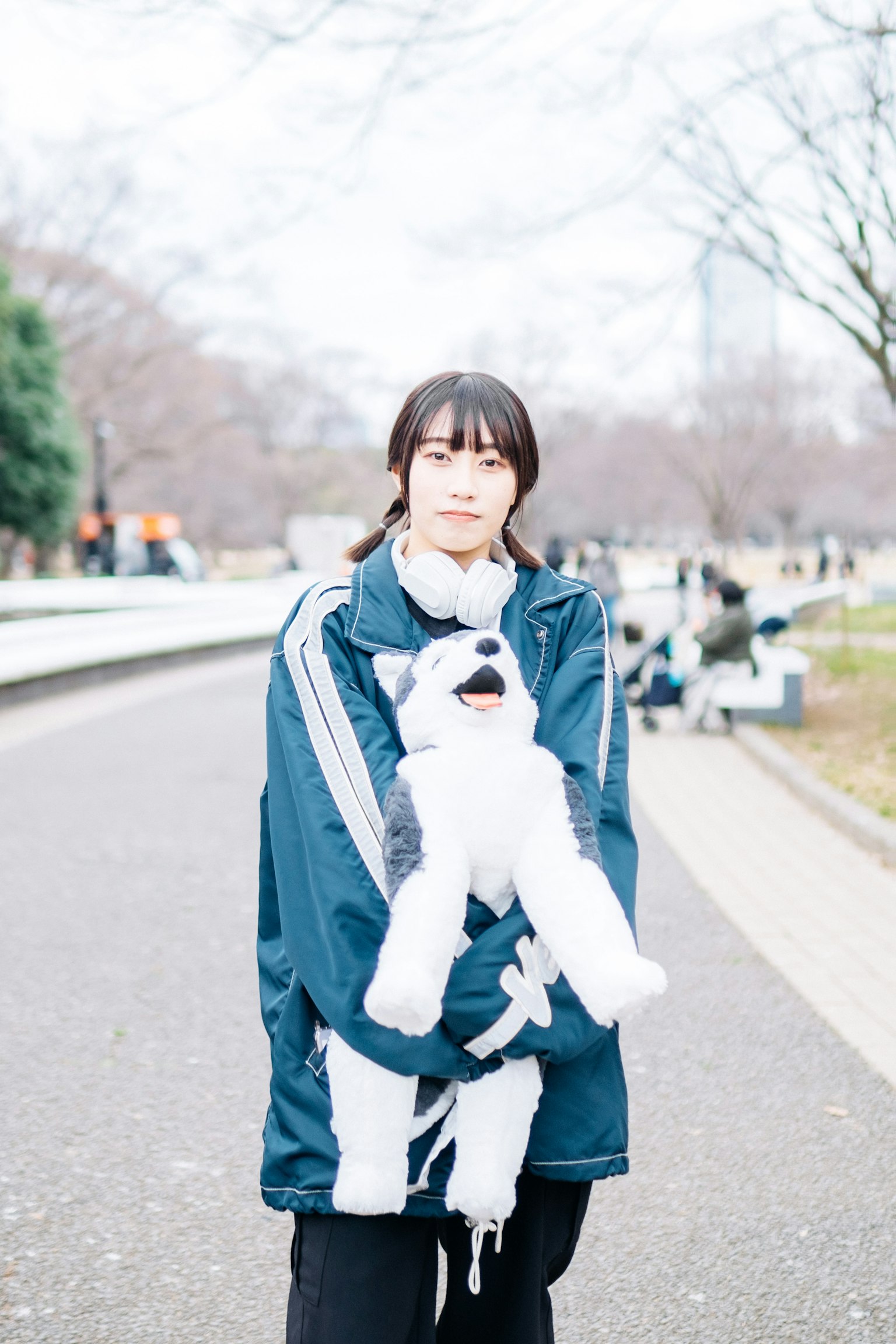 Wanita memegang anjing plush di taman