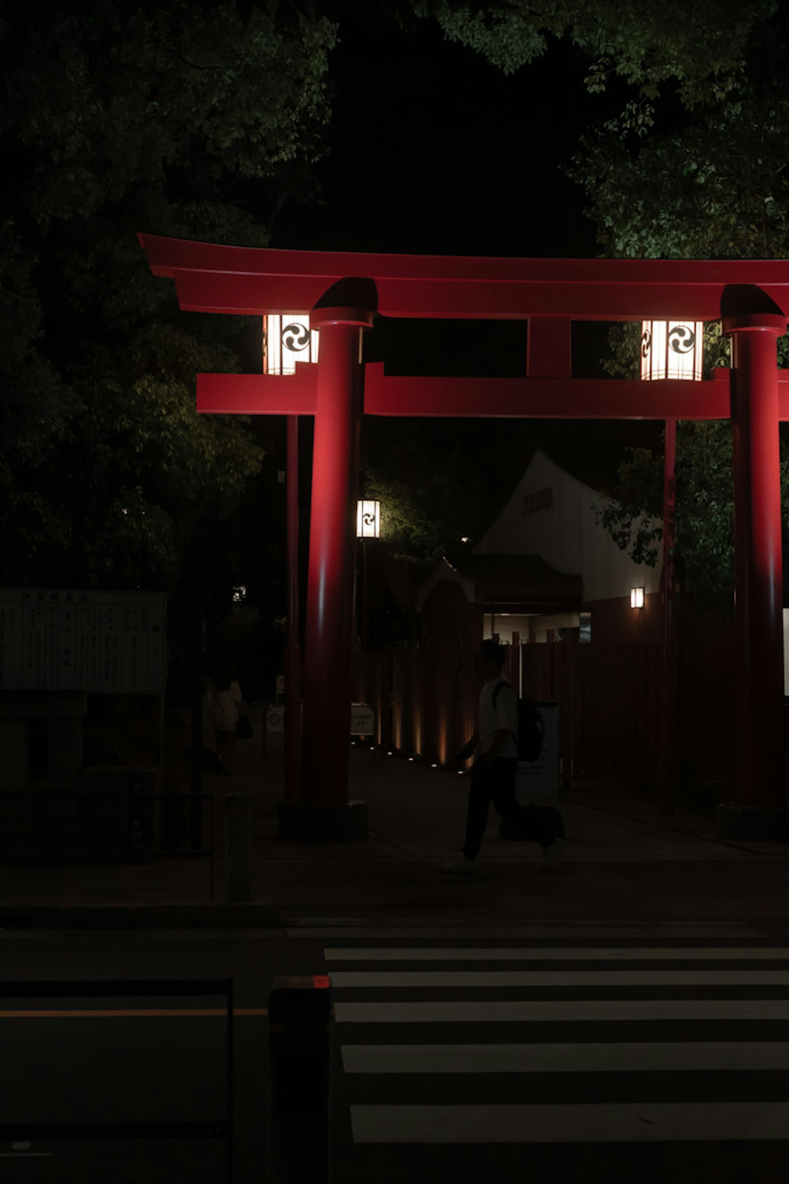 Nachtsicht eines roten Torii-Tors, beleuchtet mit Laternen