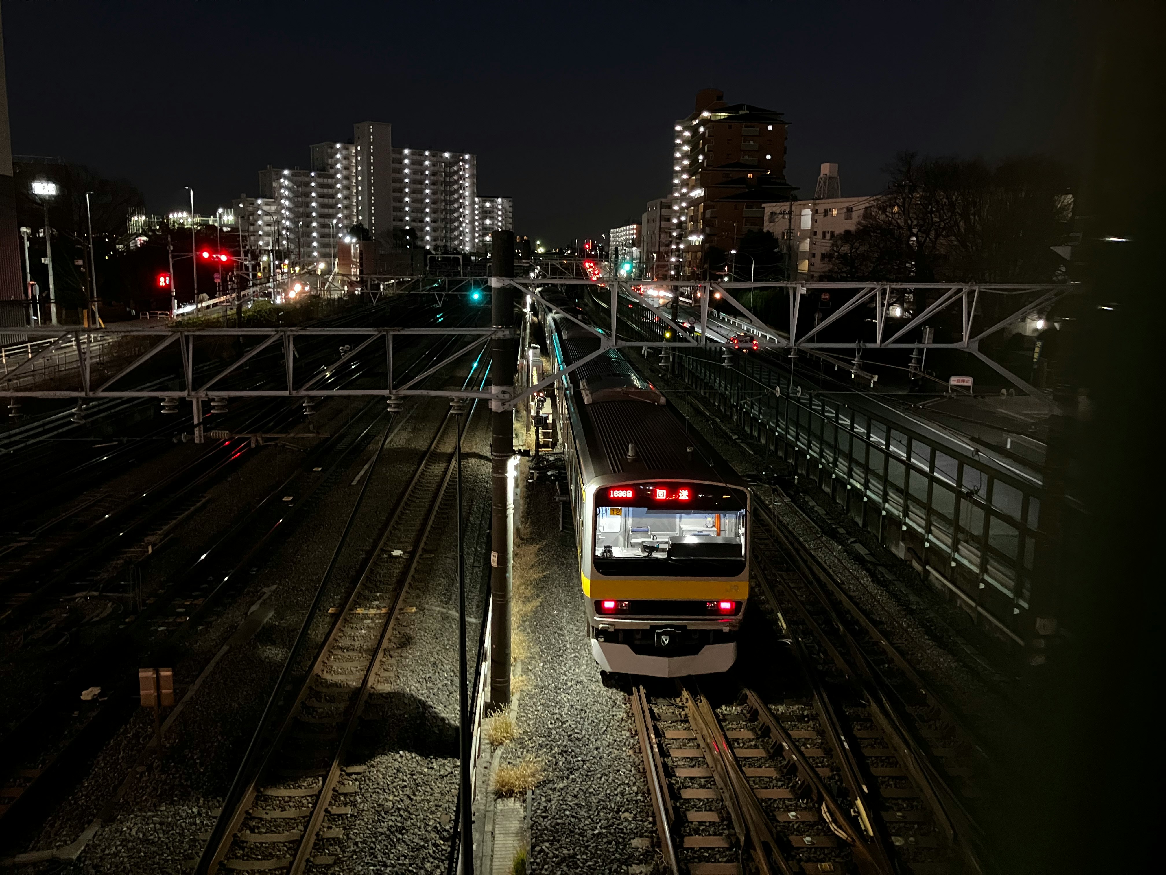 暗闇の中を走る電車と夜景の高架線路