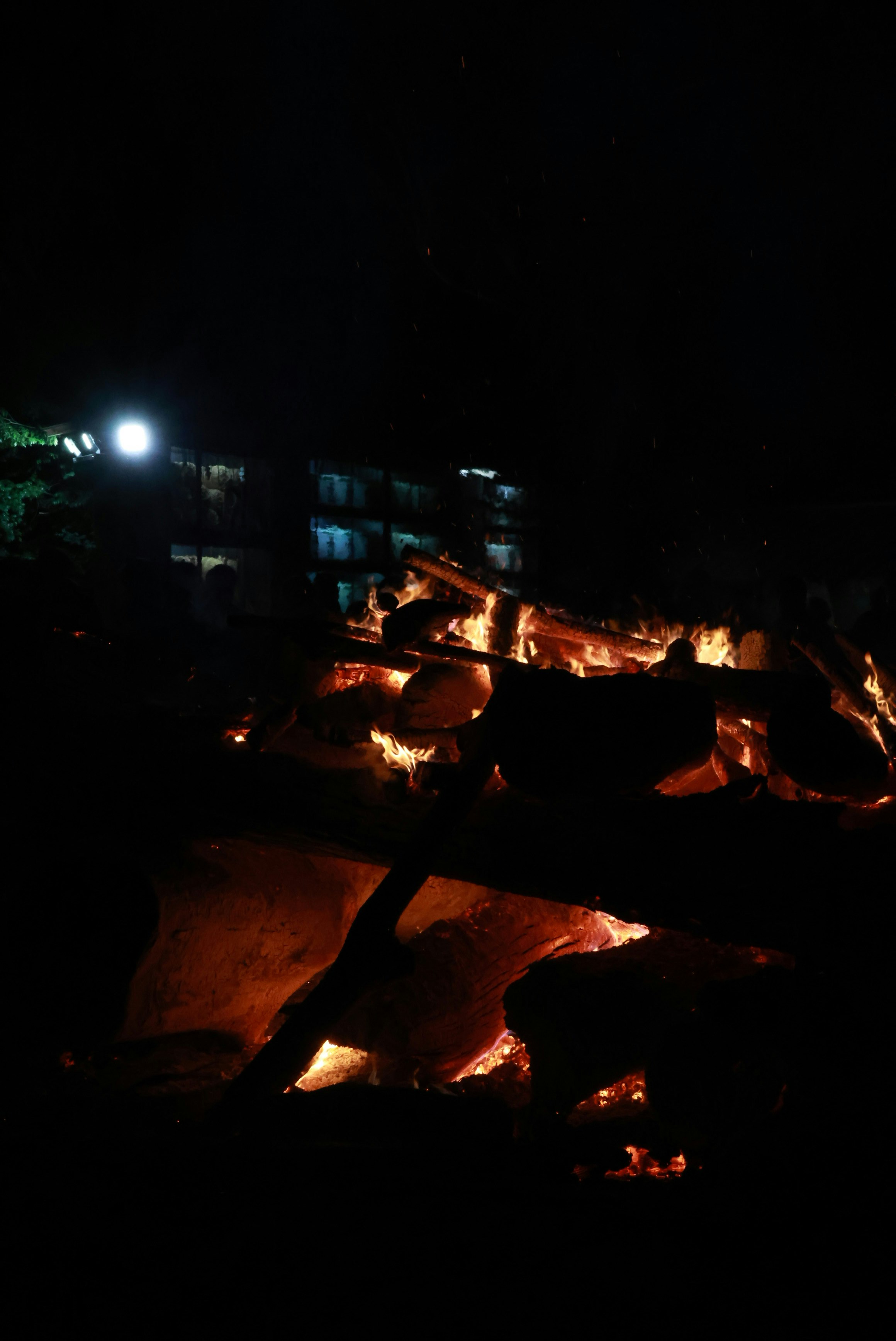 夜の川沿いに広がる灯りと火の光景