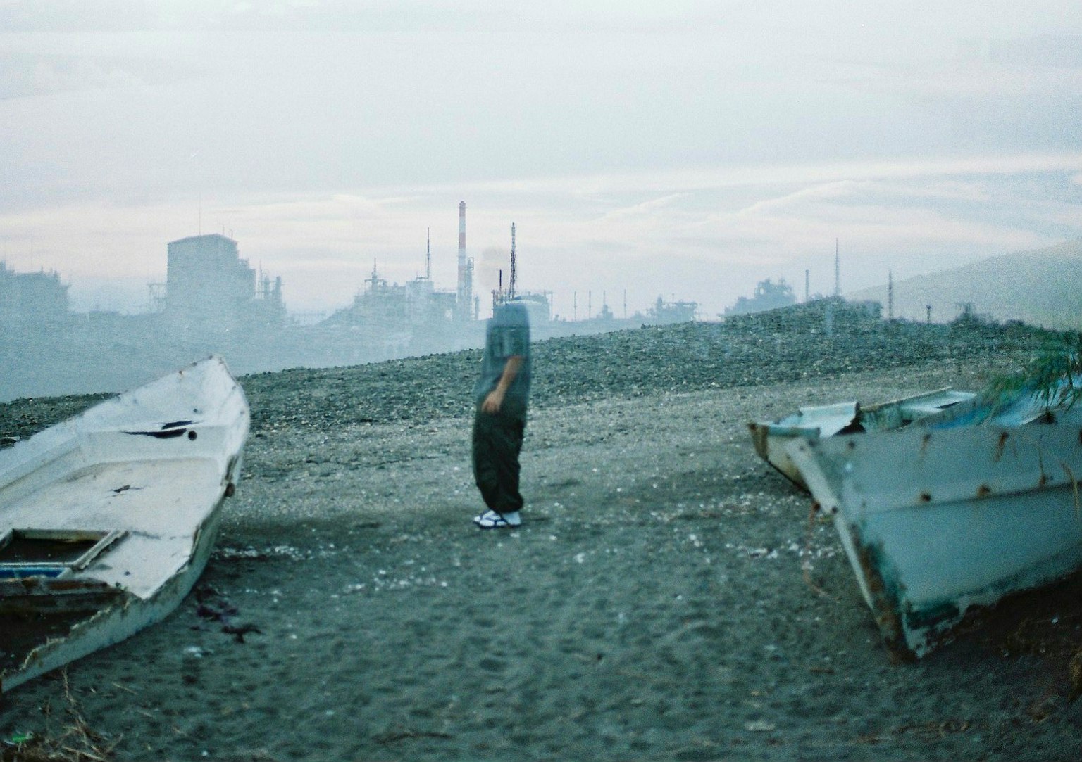 Personne debout sur une plage avec des bateaux naufragés en arrière-plan