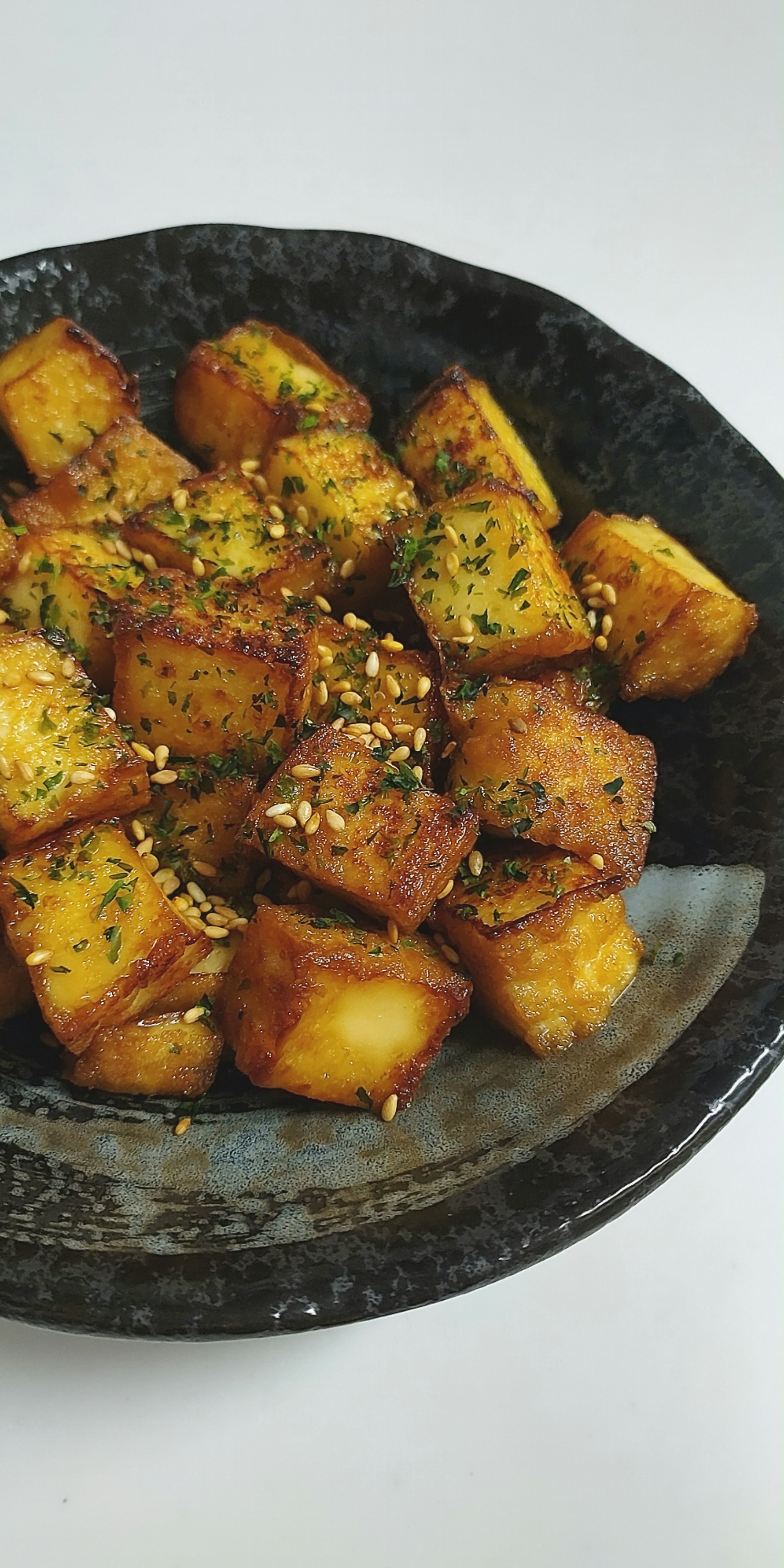 黒い皿に盛ったスパイス香る厚揚げのカリカリ焼き