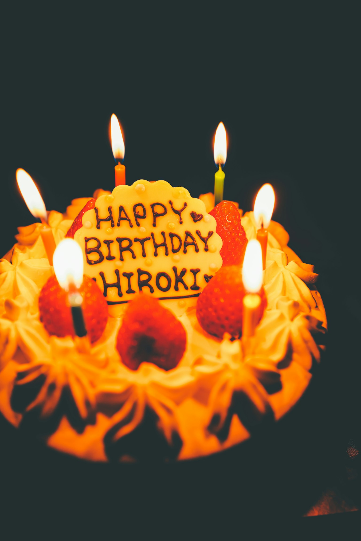 Kue ulang tahun dihias dengan stroberi dan lilin yang bertuliskan Selamat Ulang Tahun Hiroki