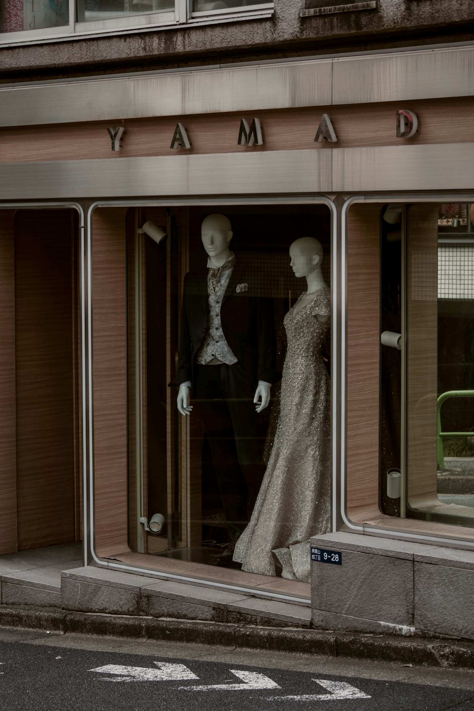 Schaufenster mit männlichen und weiblichen Schaufensterpuppen in Smoking und Hochzeitskleid Name des Geschäfts ist YAMADA