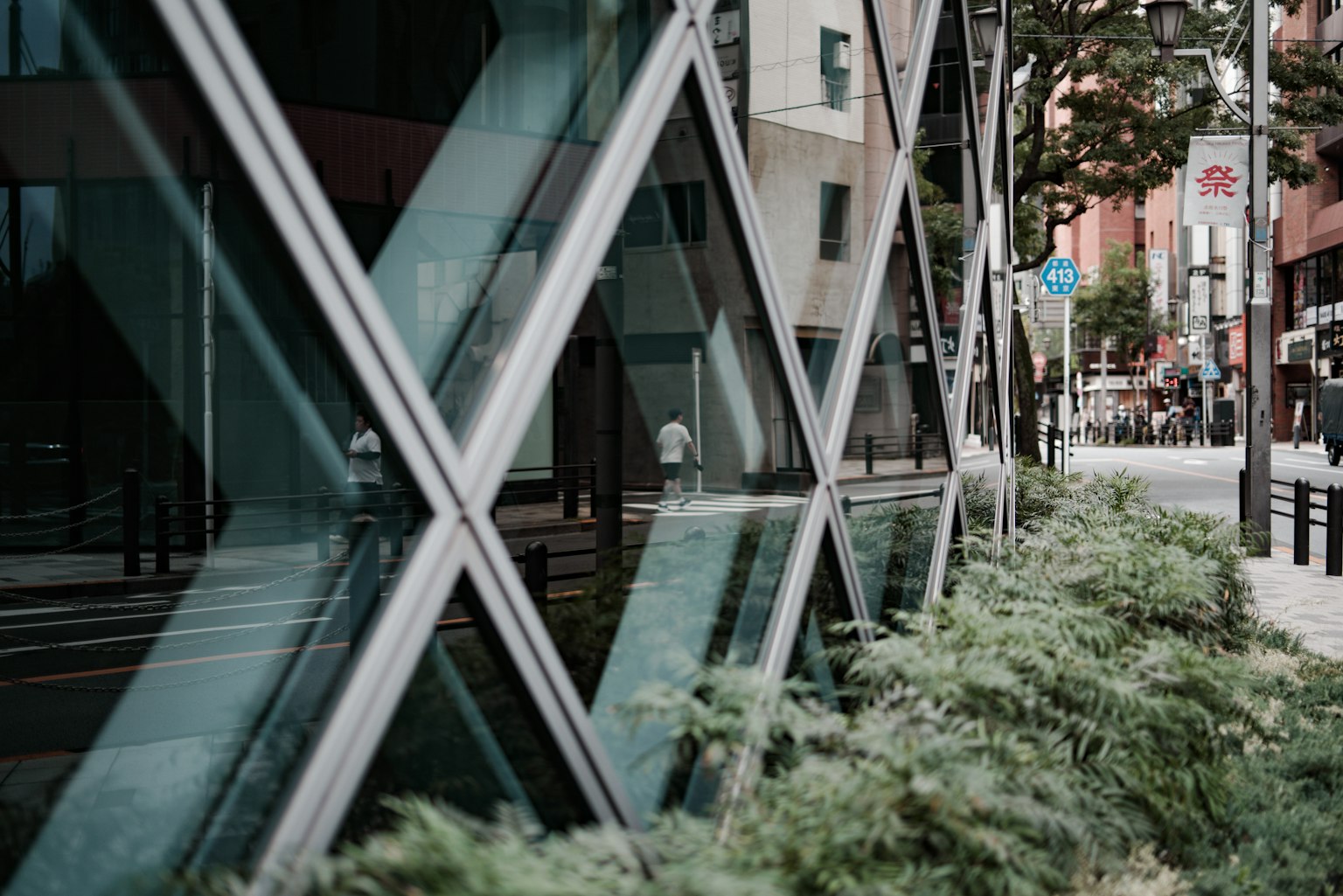 Bâtiment moderne reflétant l'environnement urbain avec de la verdure