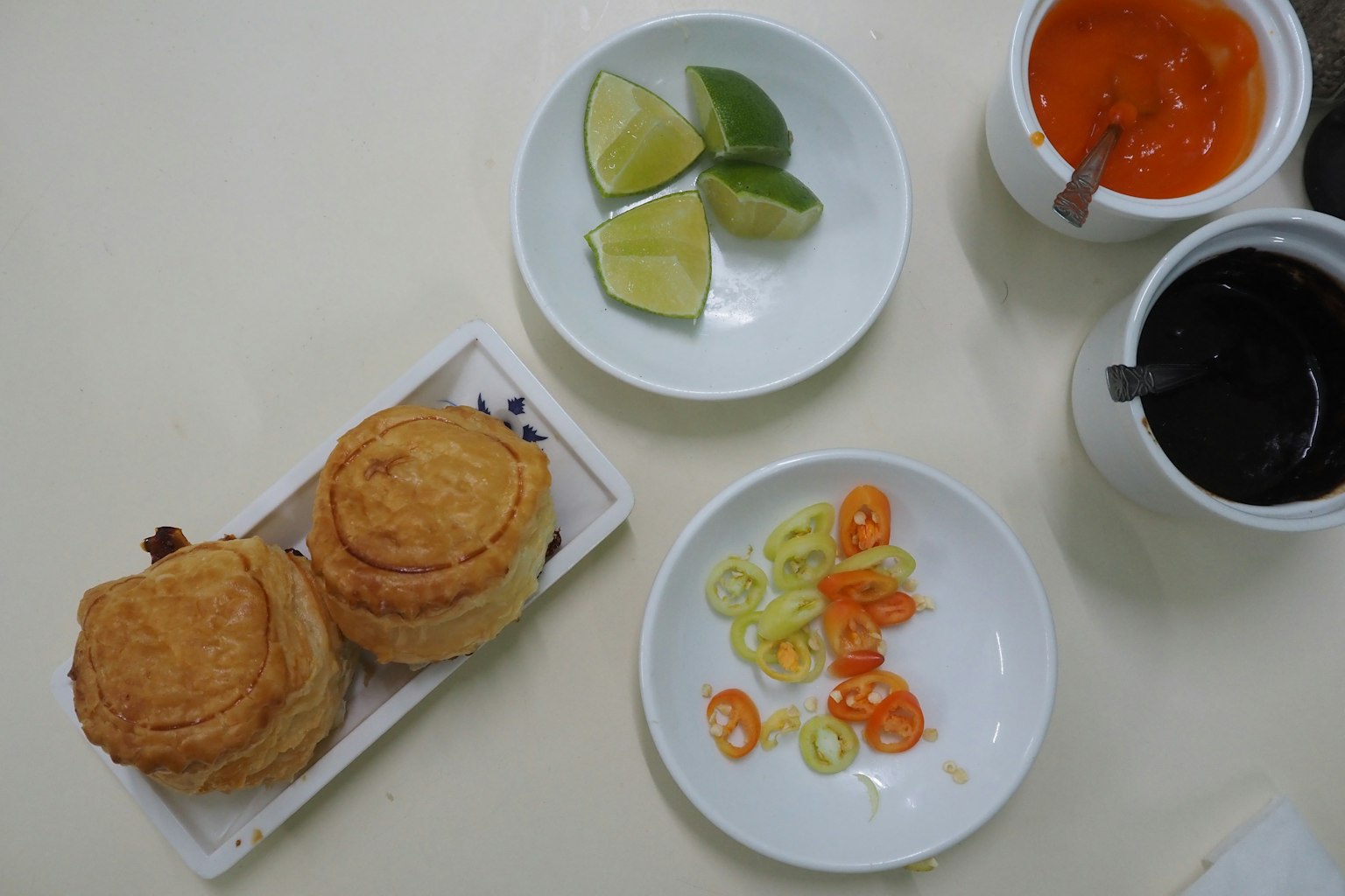 ขนมอบสองชิ้นบนโต๊ะพร้อมมะนาวพริกสไลซ์ซอสส้มซอสดำ