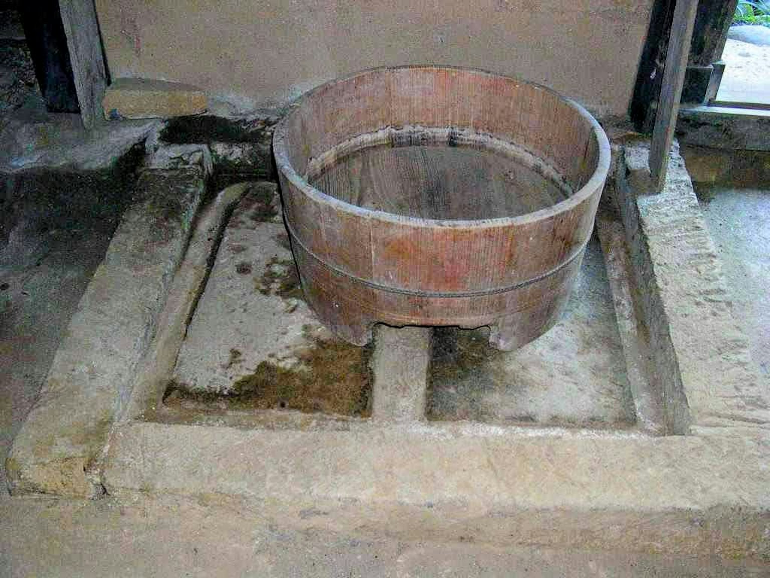 Secchio di legno posato su un pavimento di terra